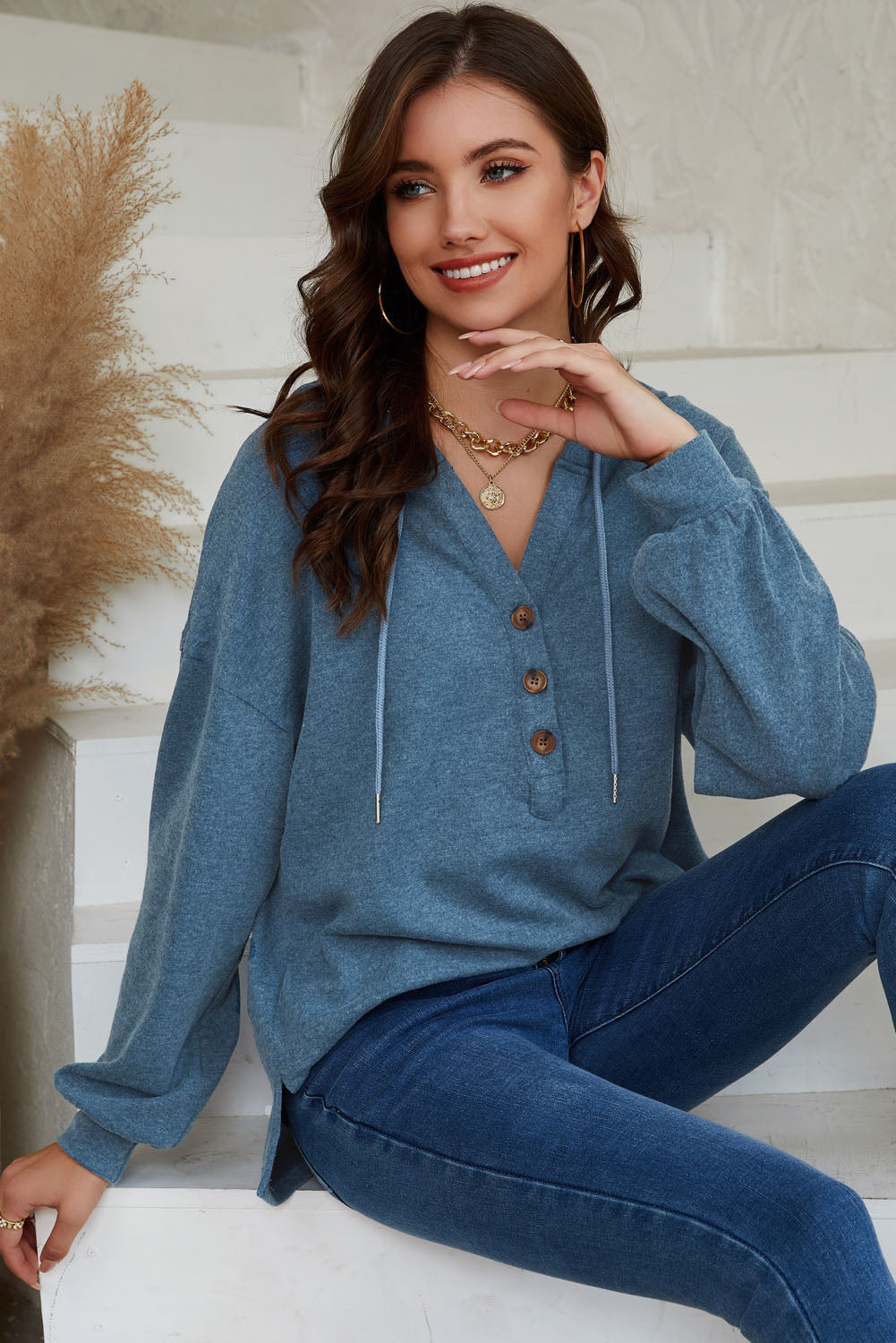 Sky Blue Buttoned High and Low Hem Hoodie with drawstring hood and tortoiseshell buttons, showcasing a relaxed fit and side slits.