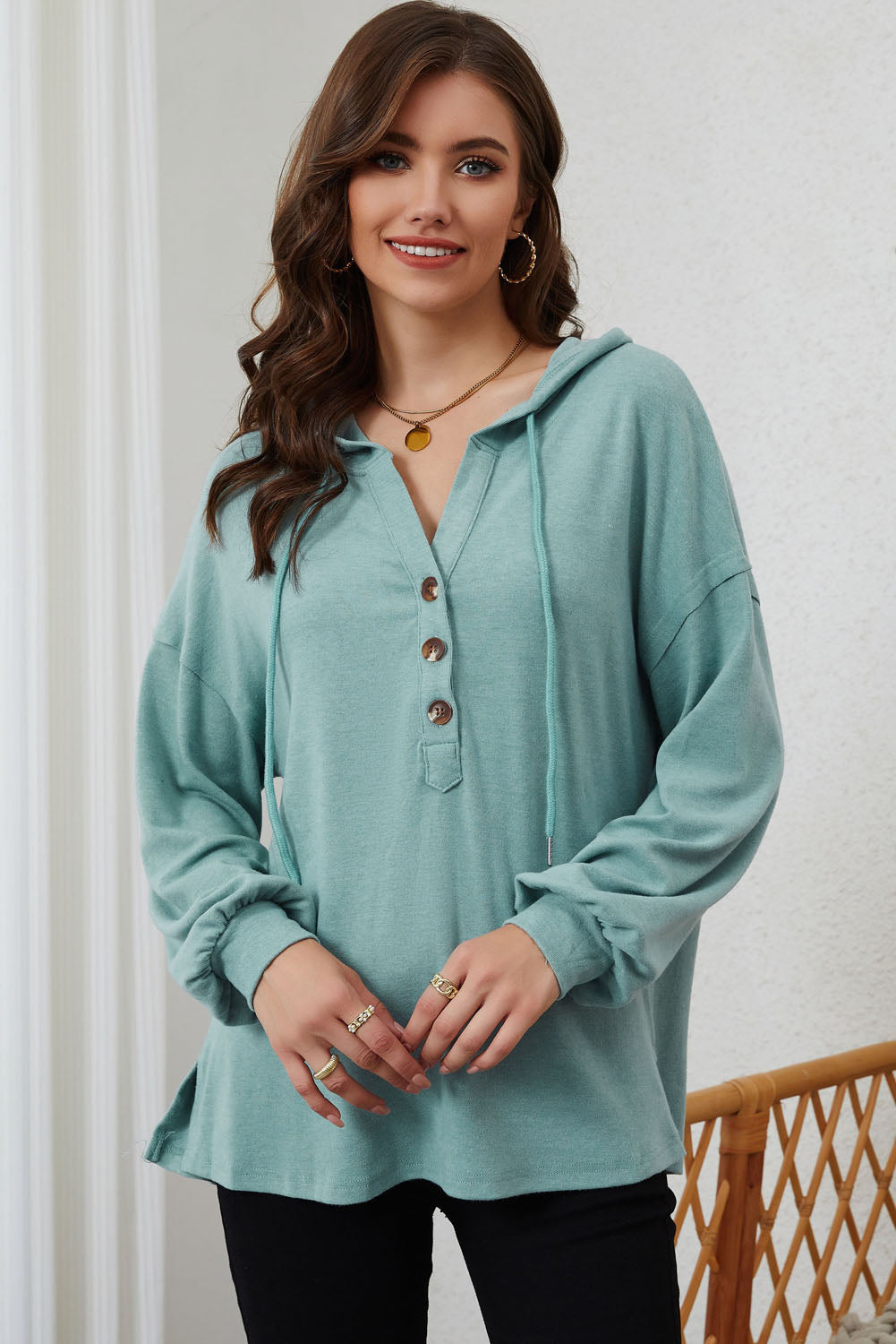 Sky Blue Buttoned High and Low Hem Hoodie with drawstring hood and tortoiseshell buttons, showcasing a relaxed fit and side slits.