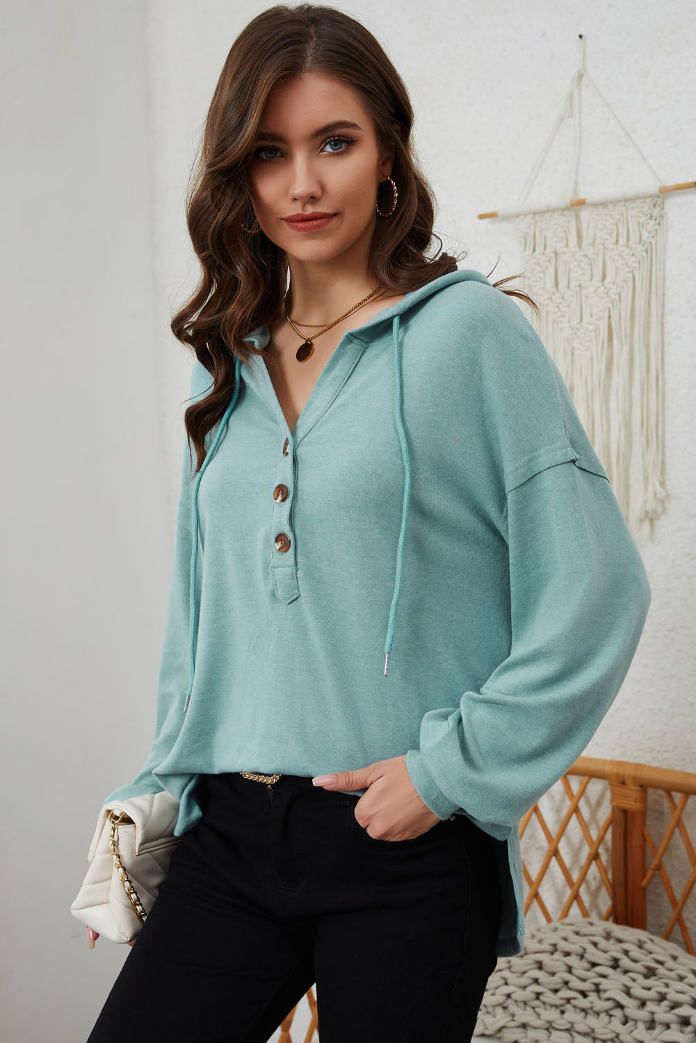 Sky Blue Buttoned High and Low Hem Hoodie with drawstring hood and tortoiseshell buttons, showcasing a relaxed fit and side slits.