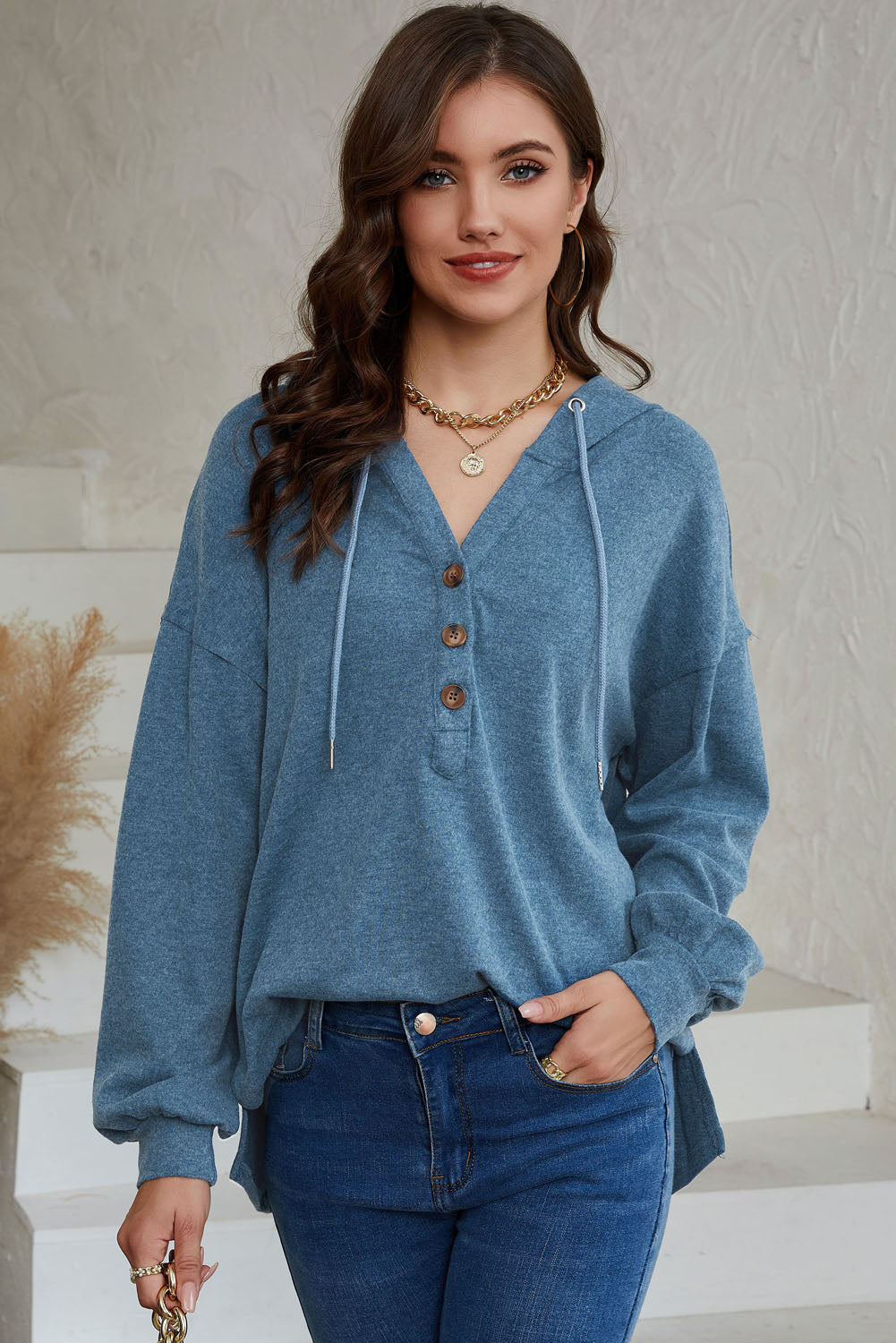 Sky Blue Buttoned High and Low Hem Hoodie with drawstring hood and tortoiseshell buttons, showcasing a relaxed fit and side slits.