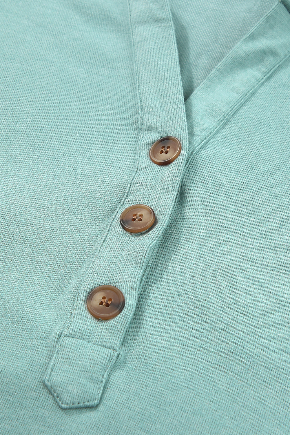 Sky Blue Buttoned High and Low Hem Hoodie with drawstring hood and tortoiseshell buttons, showcasing a relaxed fit and side slits.