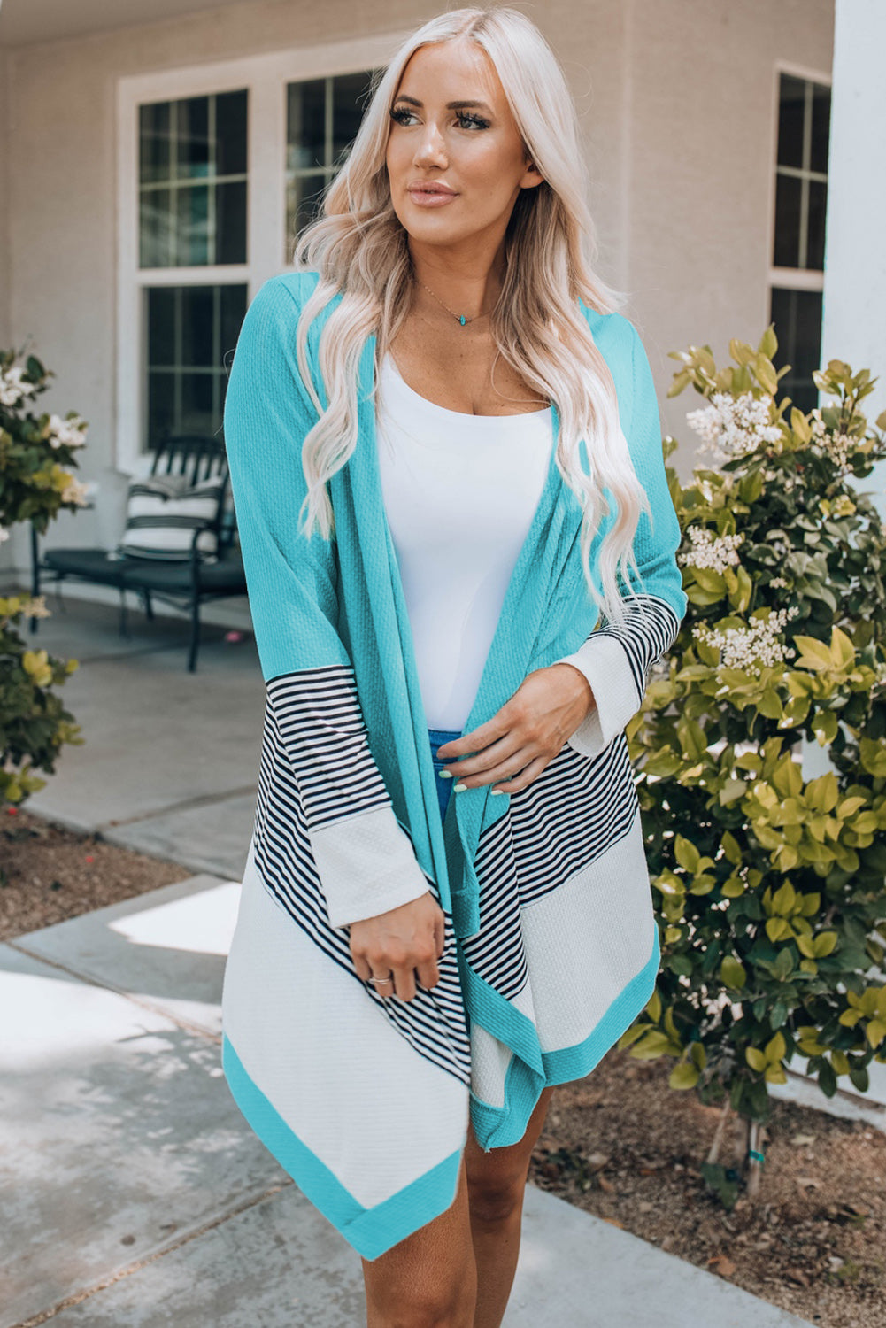 Sky blue loose fit cardigan featuring a striped print and color block design, open front, long sleeves, and an asymmetric hemline.