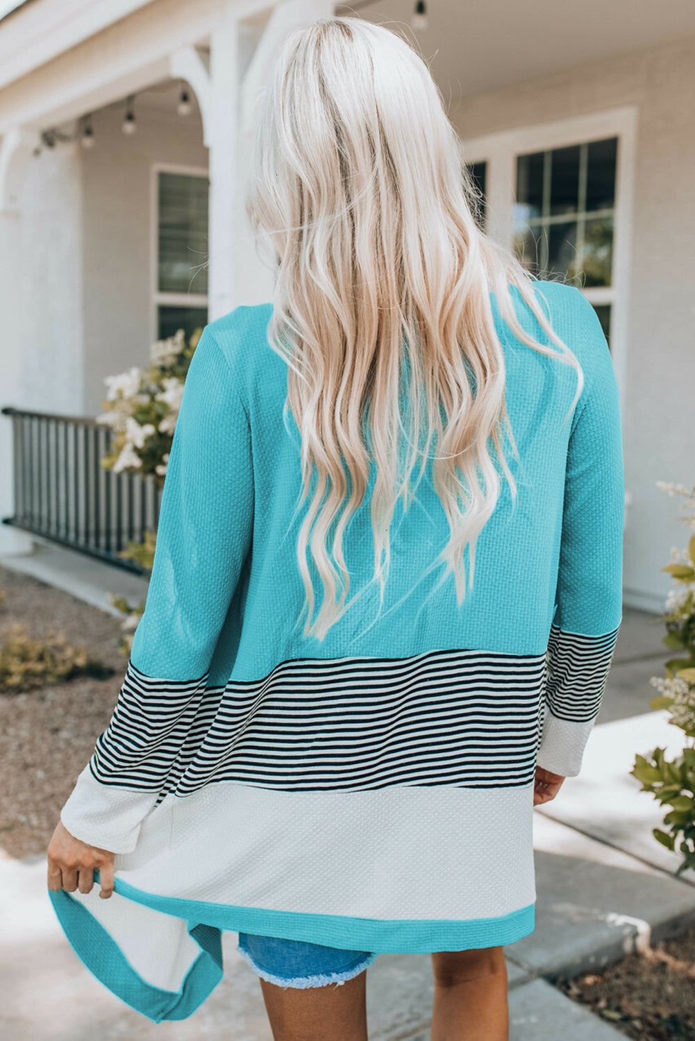 Sky blue loose fit cardigan featuring a striped print and color block design, open front, long sleeves, and an asymmetric hemline.