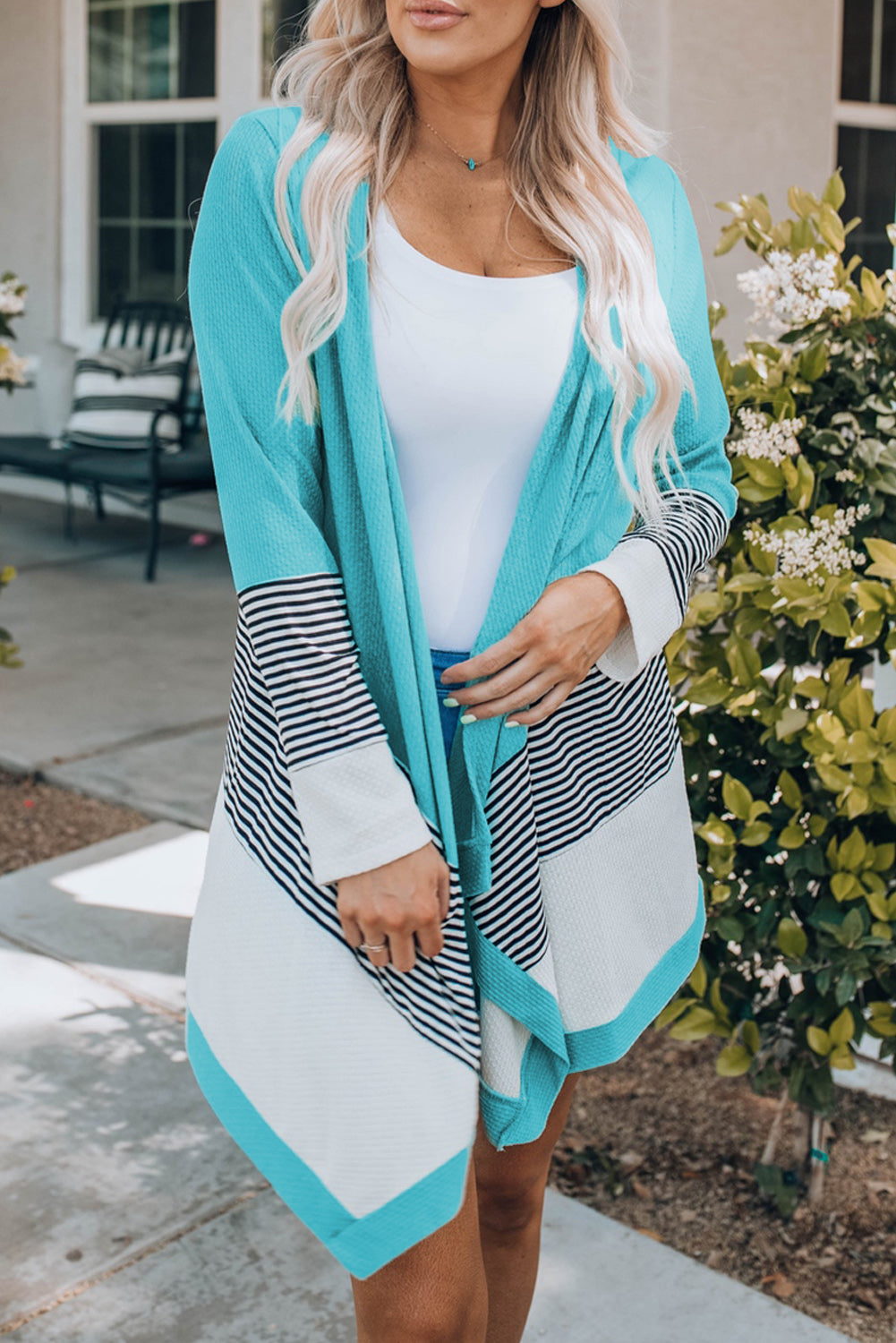 Sky blue loose fit cardigan featuring a striped print and color block design, open front, long sleeves, and an asymmetric hemline.