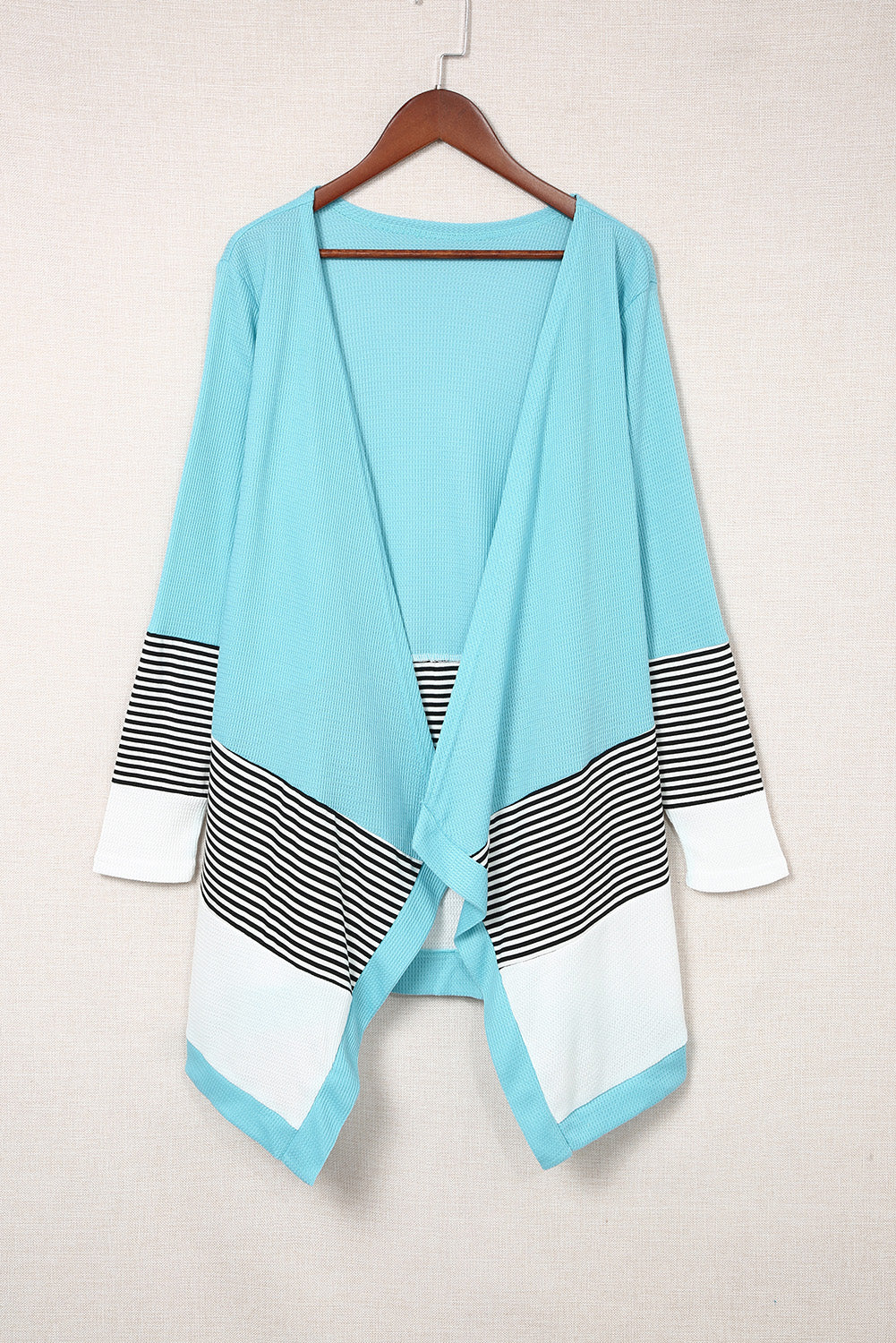 Sky blue loose fit cardigan featuring a striped print and color block design, open front, long sleeves, and an asymmetric hemline.