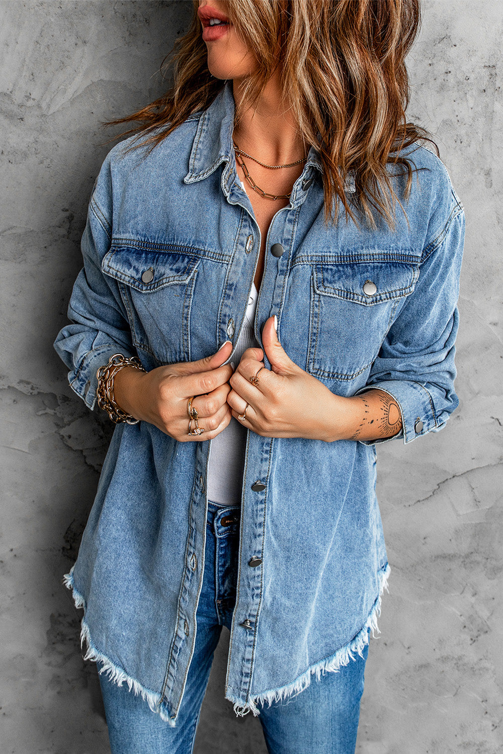 Sky blue denim jacket featuring a raw hem, button closure, and flap pocket, perfect for casual wear.