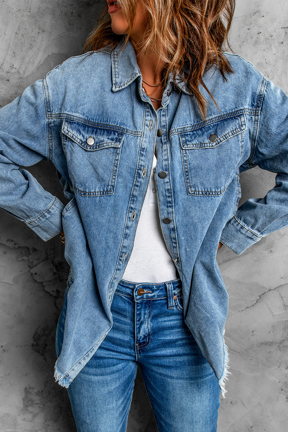 Sky blue denim jacket featuring a raw hem, button closure, and flap pocket, perfect for casual wear.