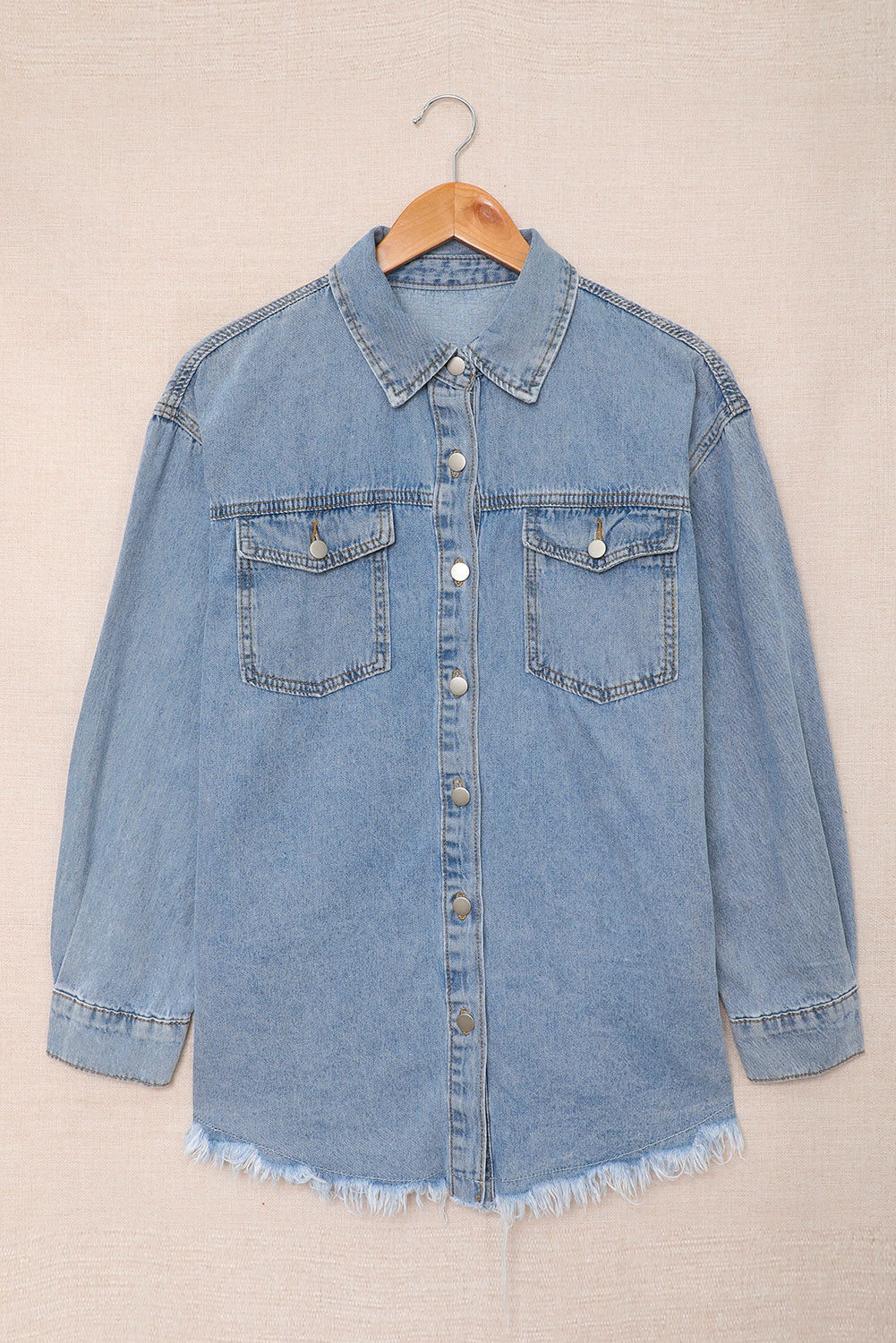 Sky blue denim jacket featuring a raw hem, button closure, and flap pocket, perfect for casual wear.