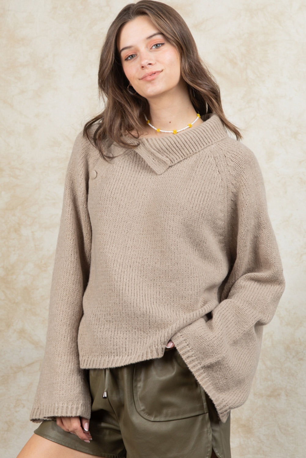 Smoke gray sweater with wide sleeves and high neck, featuring side buttons for adjustable styling.