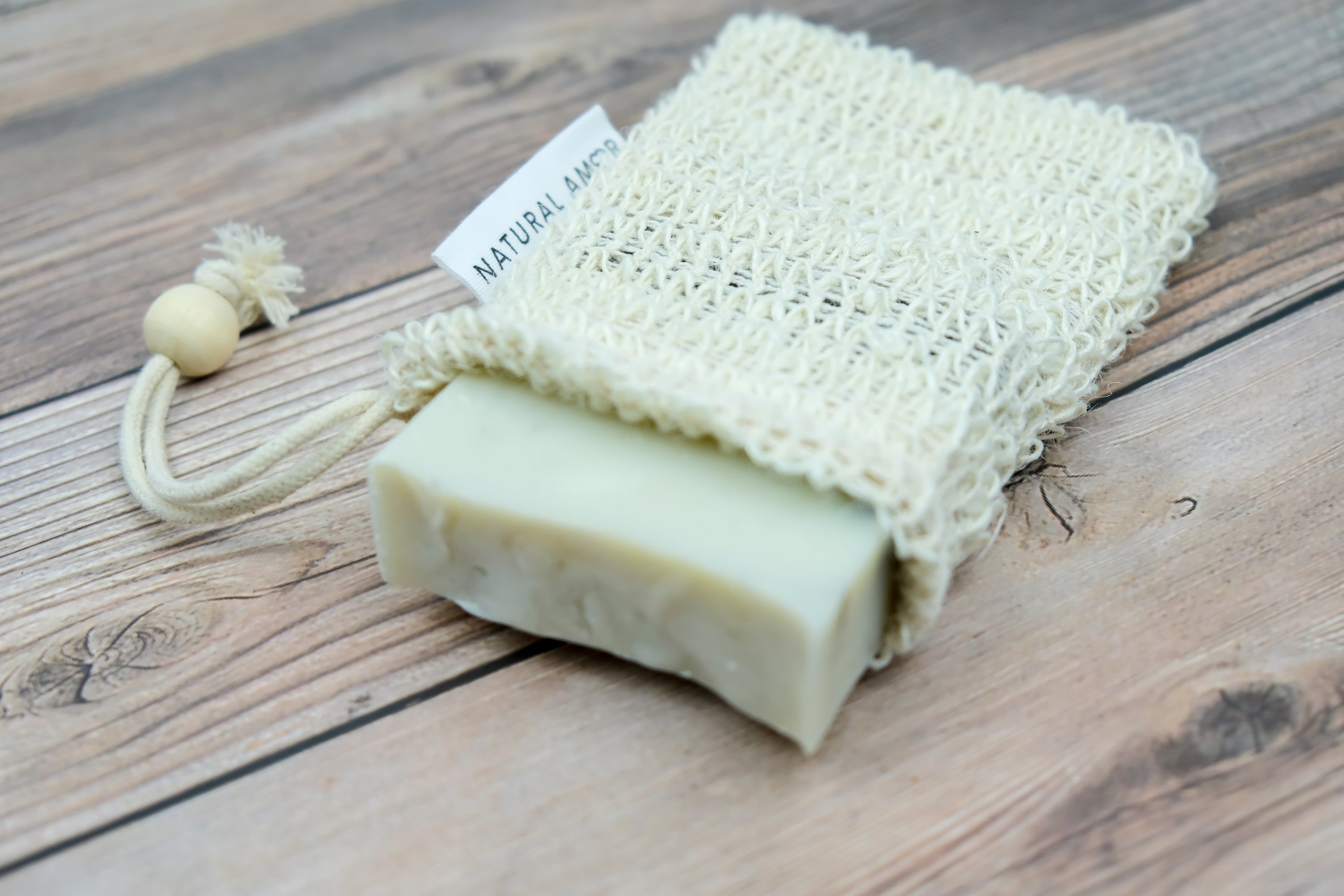 Natural Amor Soap Saver Net made of linen and cotton, designed to hold and dry handmade soap bars, preventing sogginess.