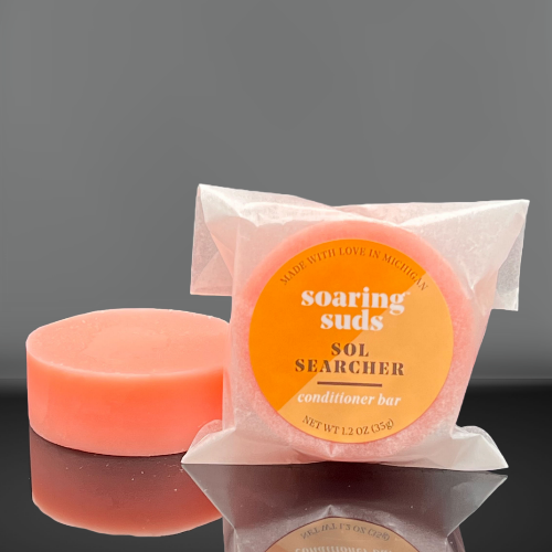 Sol Searcher Shampoo & Conditioner bars with refreshing lemon and bergamot scent, displayed on a natural wooden surface.