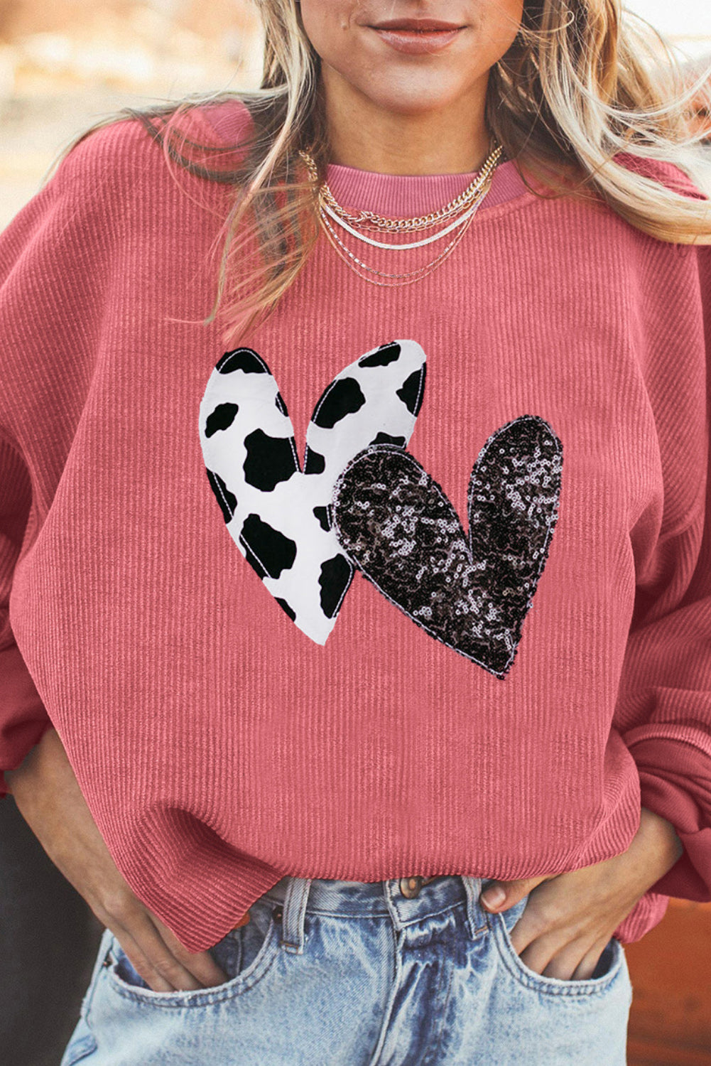 Strawberry pink corded sweatshirt featuring leopard print and sequin heart graphics, perfect for Valentine's Day fashion.