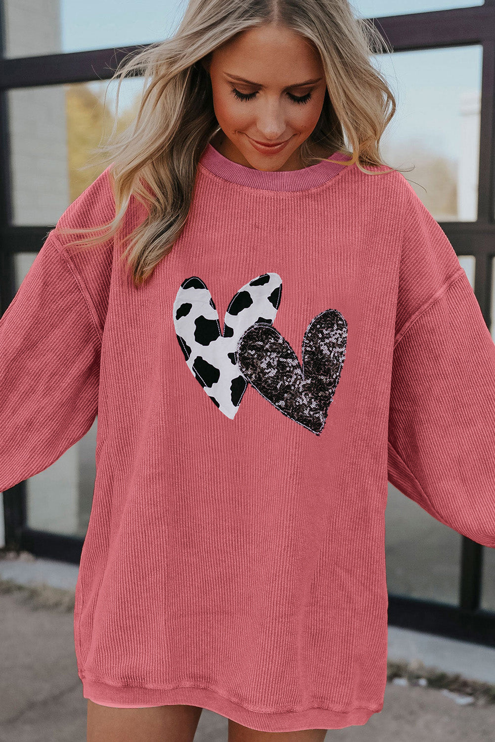 Strawberry pink corded sweatshirt featuring leopard print and sequin heart graphics, perfect for Valentine's Day fashion.