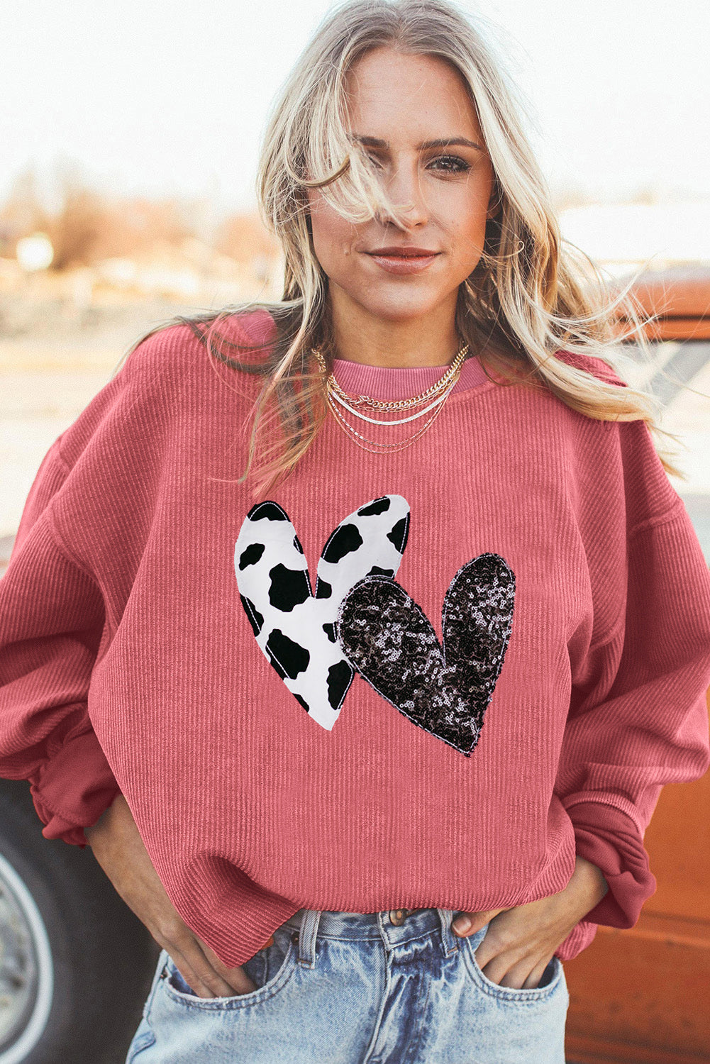 Strawberry pink corded sweatshirt featuring leopard print and sequin heart graphics, perfect for Valentine's Day fashion.