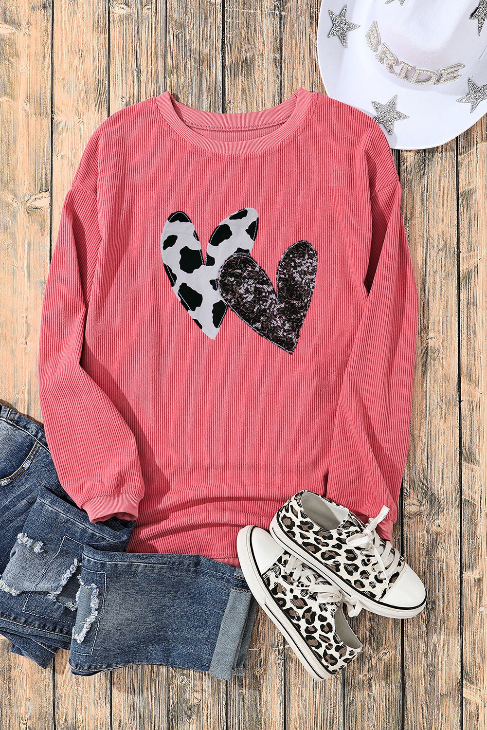 Strawberry pink corded sweatshirt featuring leopard print and sequin heart graphics, perfect for Valentine's Day fashion.