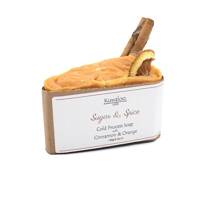 A beautifully crafted 'Sugar and Spice' soap featuring dried orange and a cinnamon stick, showcasing its vibrant orange color.