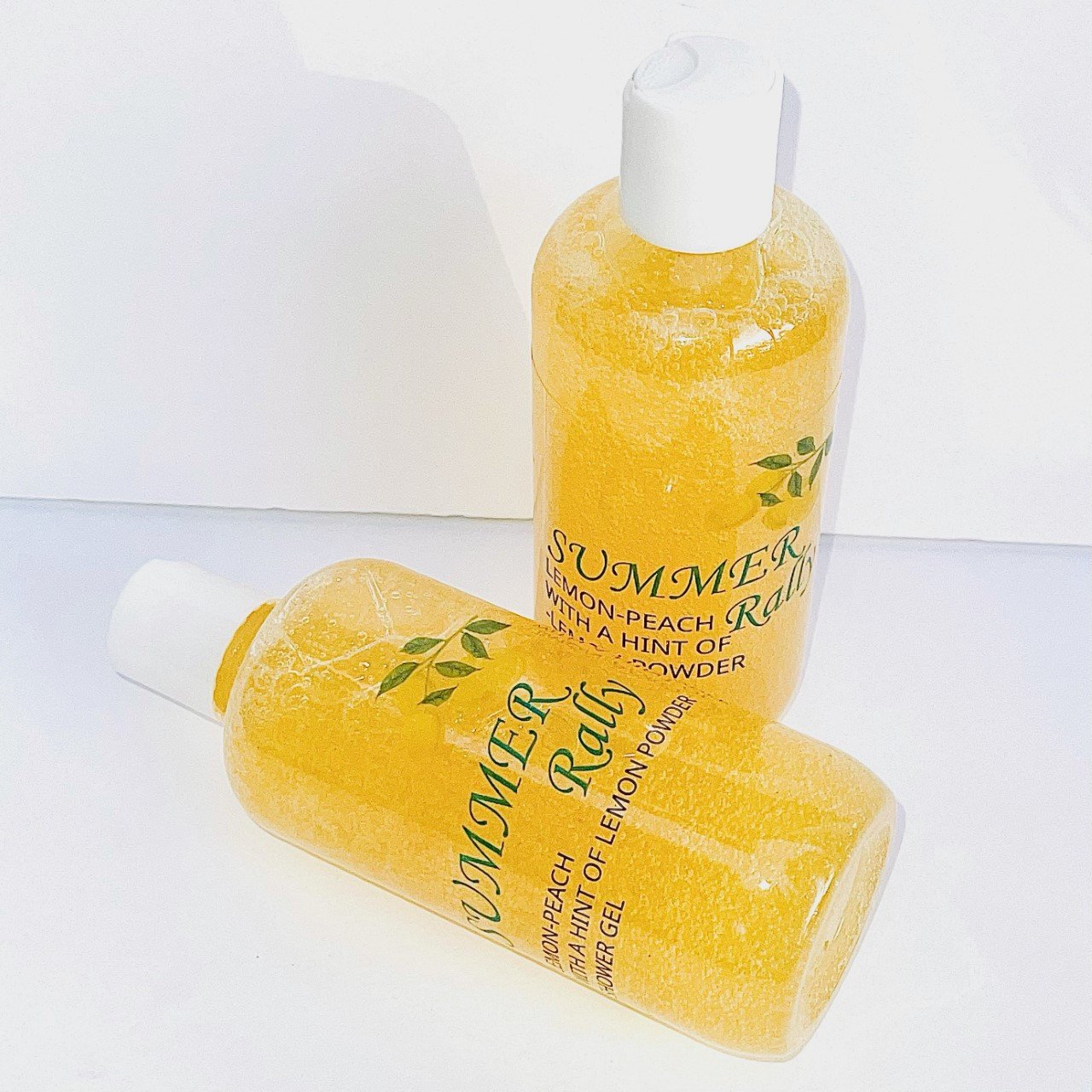 A bottle of Summer Rally Lemon Body Wash with a vibrant lemon design, showcasing its refreshing lemon-peach scent and creamy lather.