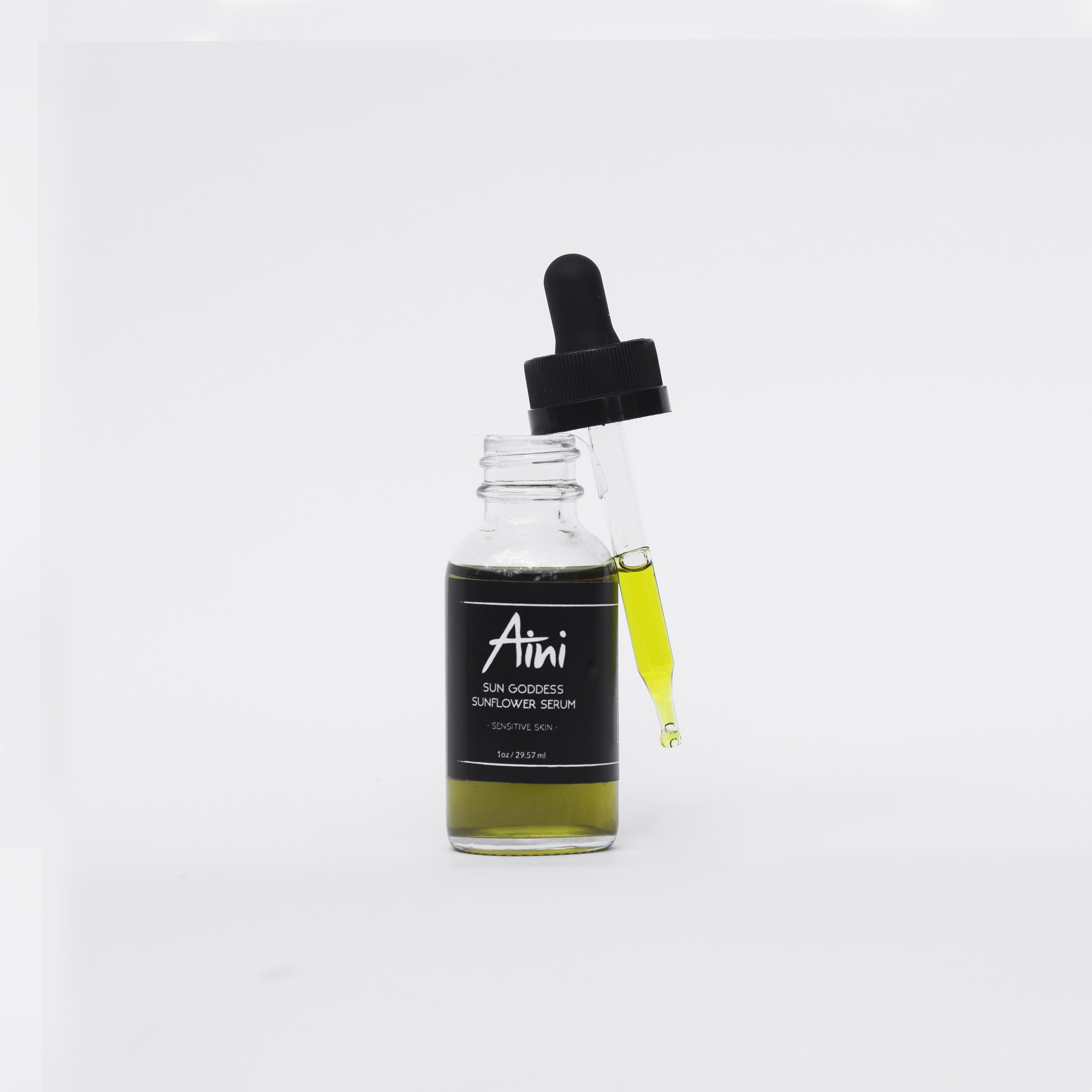 A bottle of Sunflower Serum with a dropper, showcasing its golden liquid, surrounded by sunflower petals and natural ingredients.