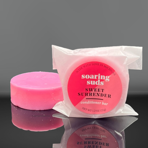 Sweet Surrender Shampoo & Conditioner bars with strawberry and champagne scent, showcasing their eco-friendly packaging and luxurious texture.