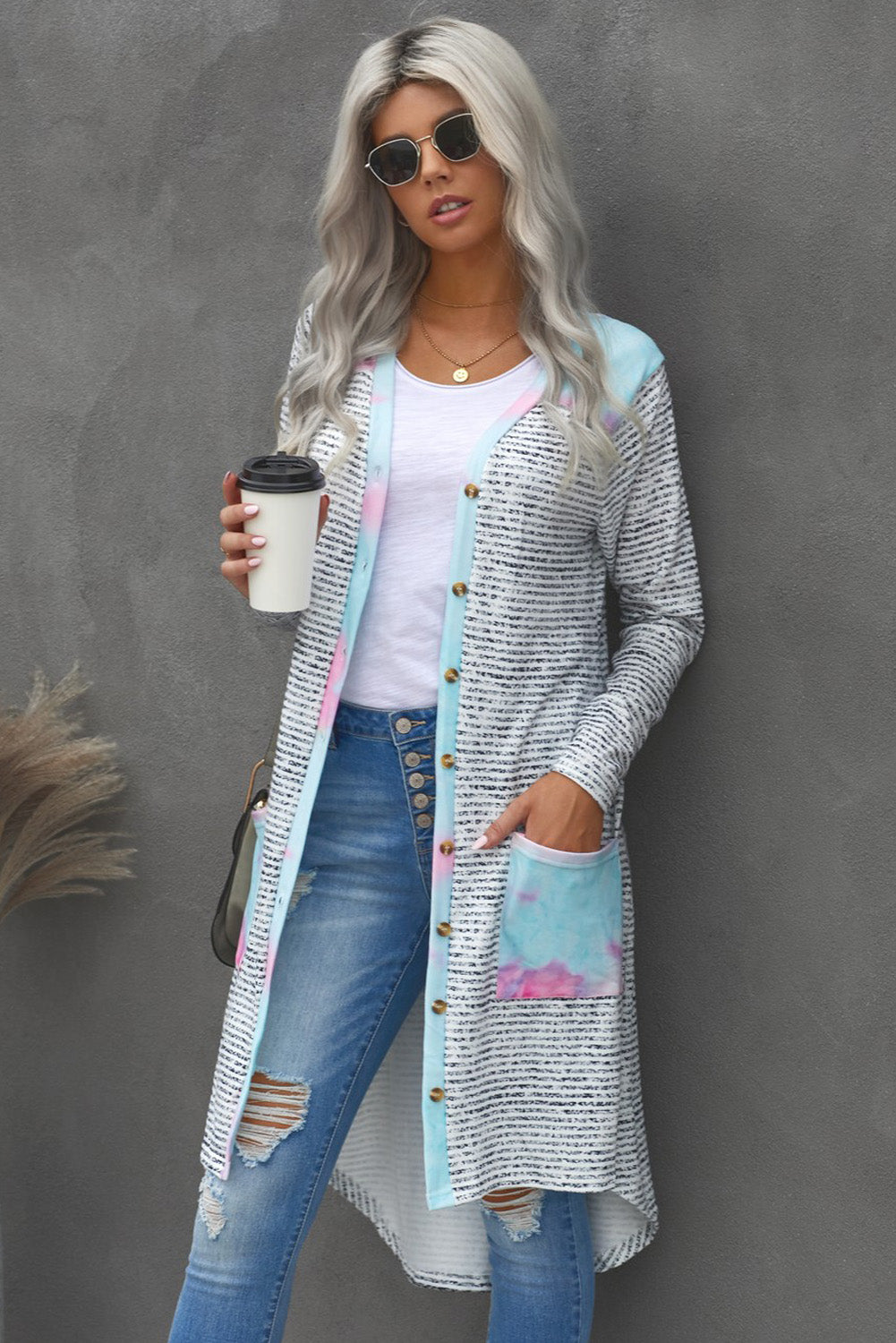 A stylish long striped cardigan featuring a vibrant tie-dye patchwork design, complete with pockets for convenience.