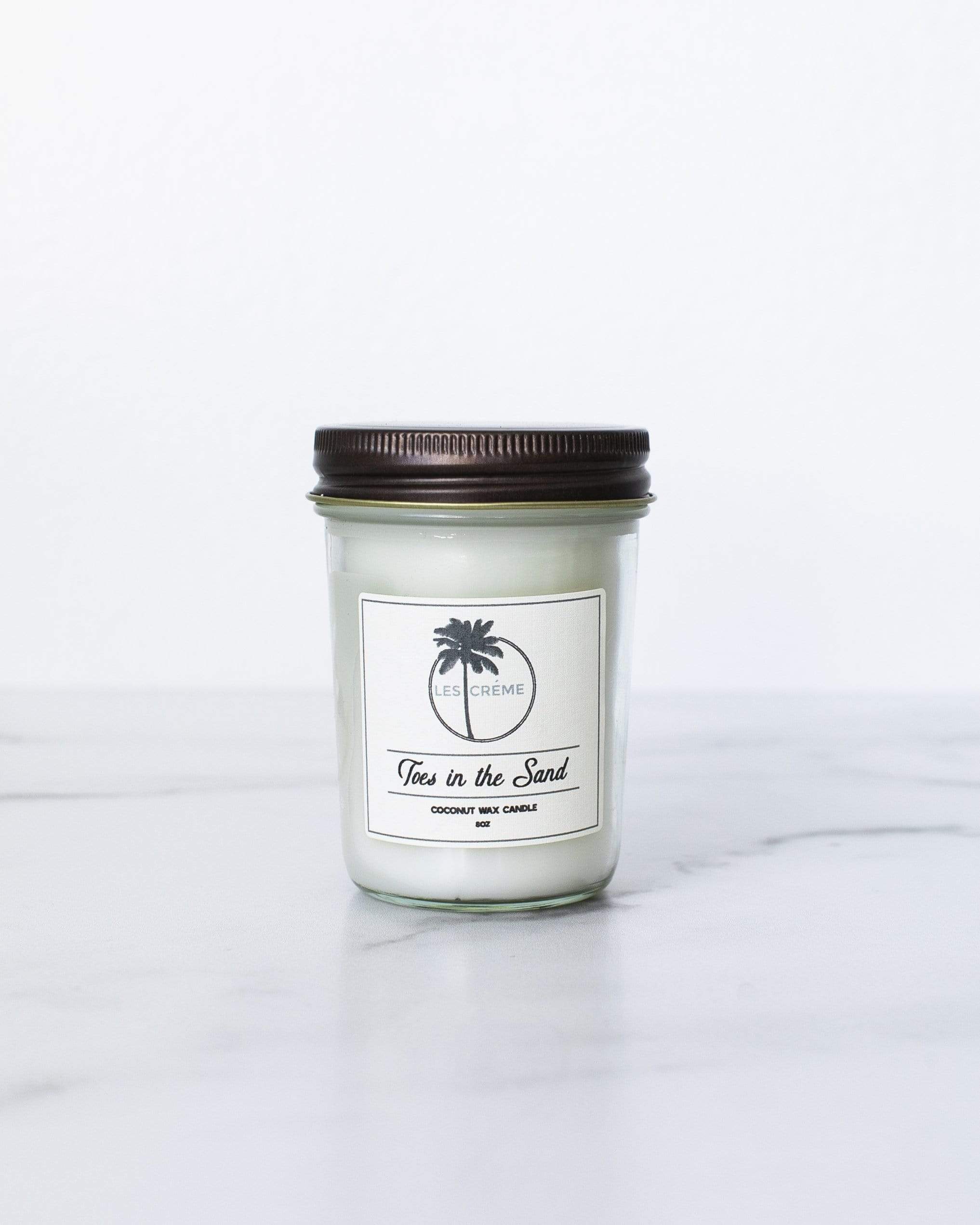 Toes in the Sand Coconut Wax Candle with floral design, showcasing its natural ingredients and elegant packaging.