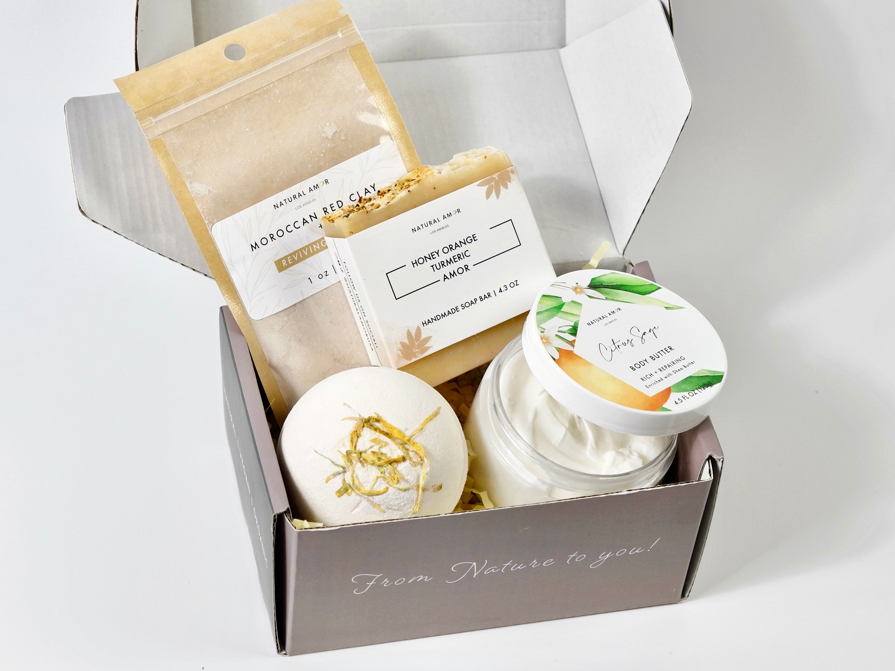 Warm & Cozy Spa Gift box featuring bath products like soap, bath bomb, body butter, and clay mask in a floral design.