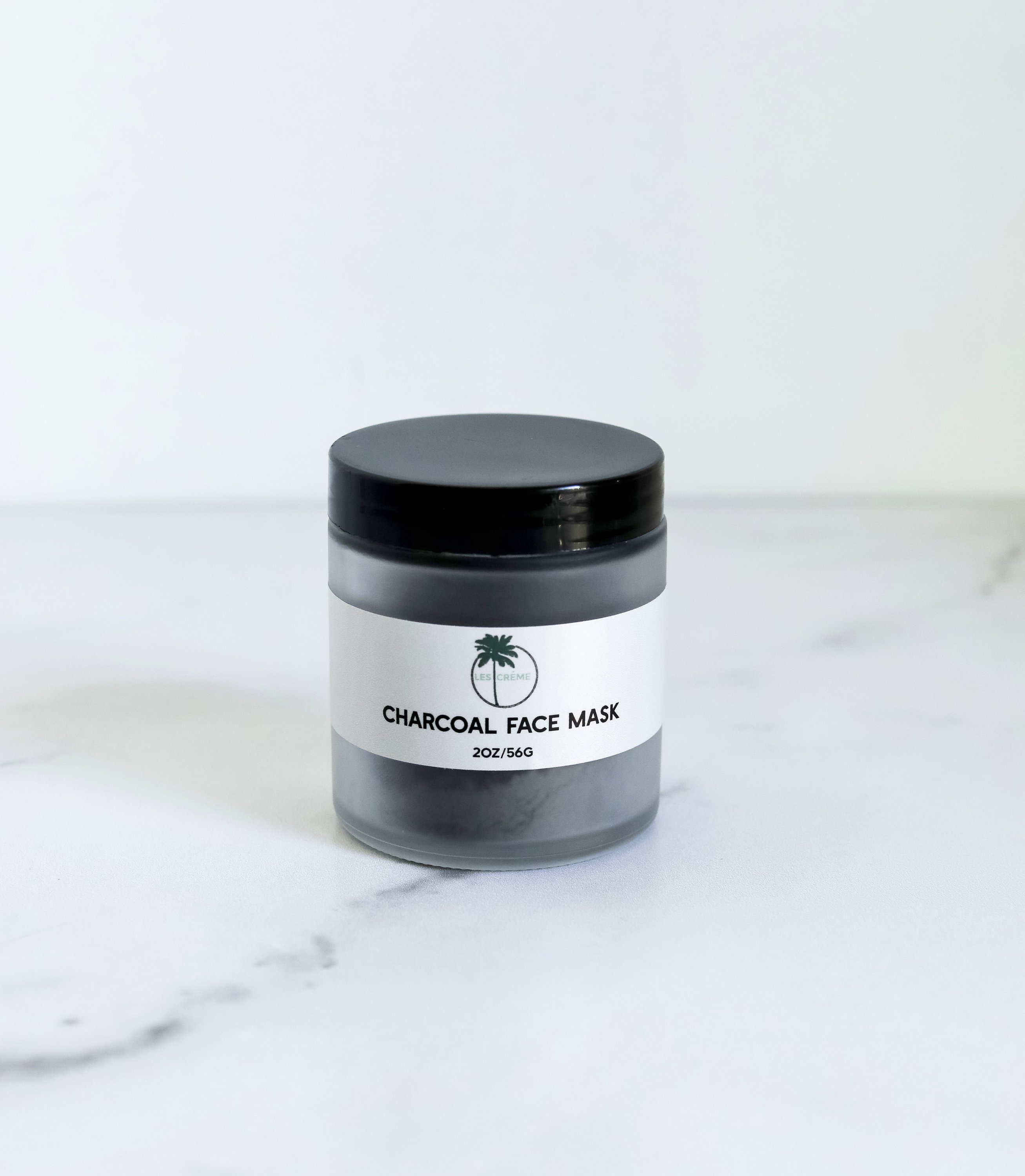 A jar of Weekly Detox Facial Mask with activated coconut charcoal and bentonite clay, showcasing its creamy texture and natural ingredients.