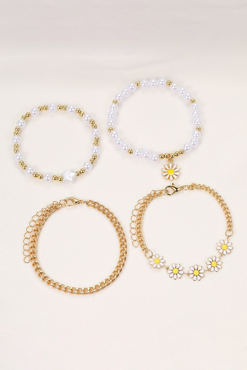 A beautiful set of four white daisy pearl beaded chain bracelets, showcasing elegant designs perfect for any occasion.