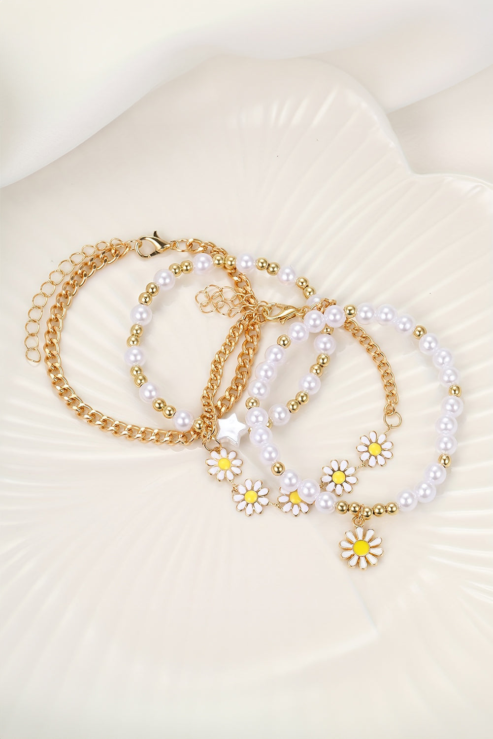 A beautiful set of four white daisy pearl beaded chain bracelets, showcasing elegant designs perfect for any occasion.