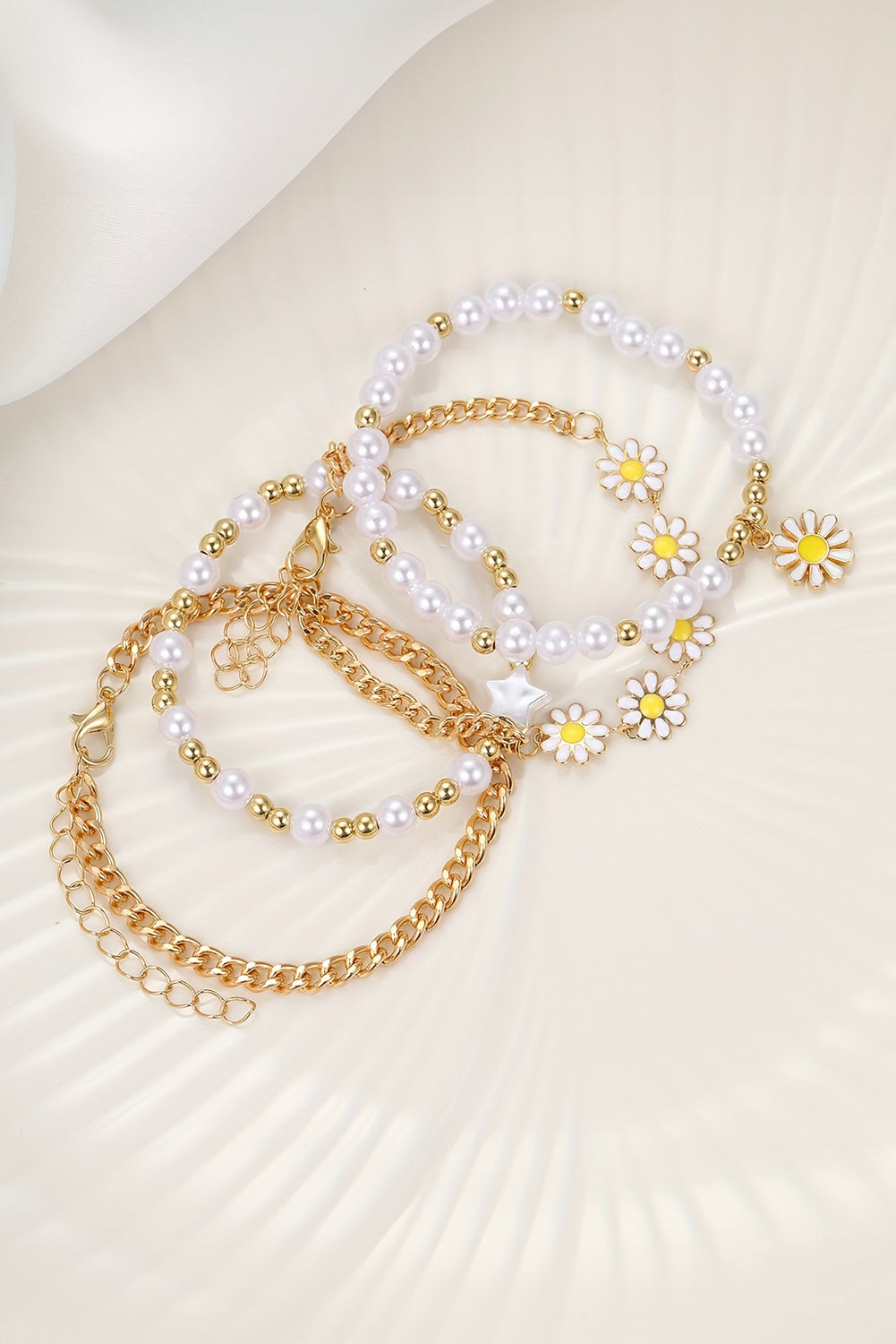 A beautiful set of four white daisy pearl beaded chain bracelets, showcasing elegant designs perfect for any occasion.