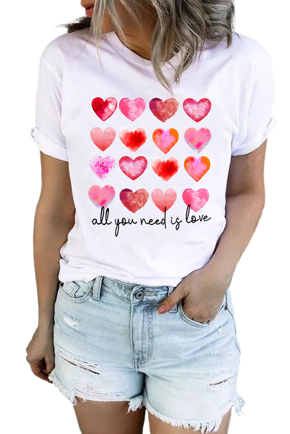 White t-shirt featuring a colorful hearts print with the text 'All You Need Is Love', perfect for casual wear.