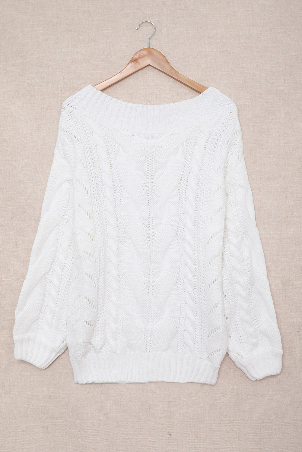 A cozy white chunky oversized pullover sweater with cable knit design, featuring a round neckline and ribbed cuffs, perfect for winter wear.