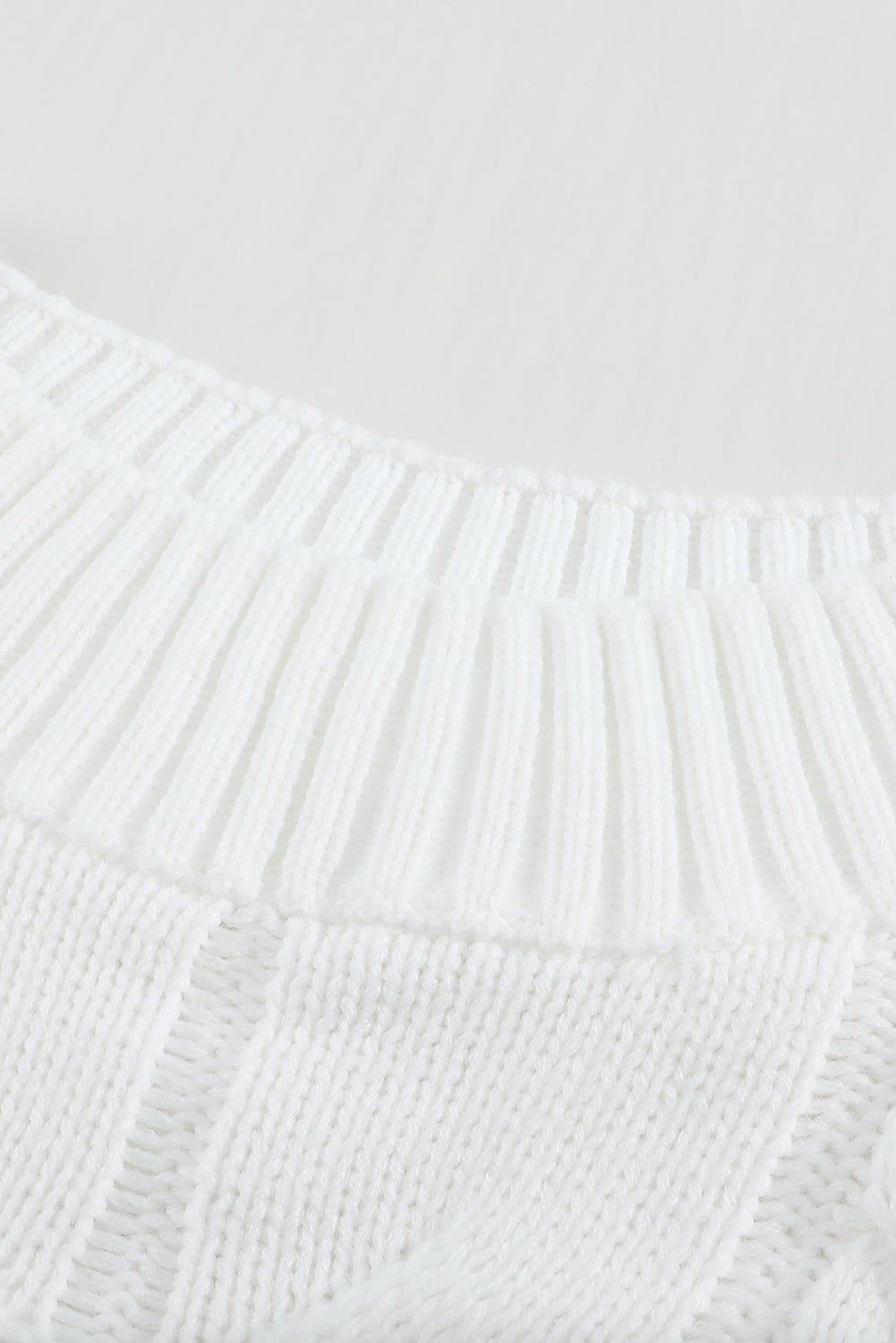 A cozy white chunky oversized pullover sweater with cable knit design, featuring a round neckline and ribbed cuffs, perfect for winter wear.