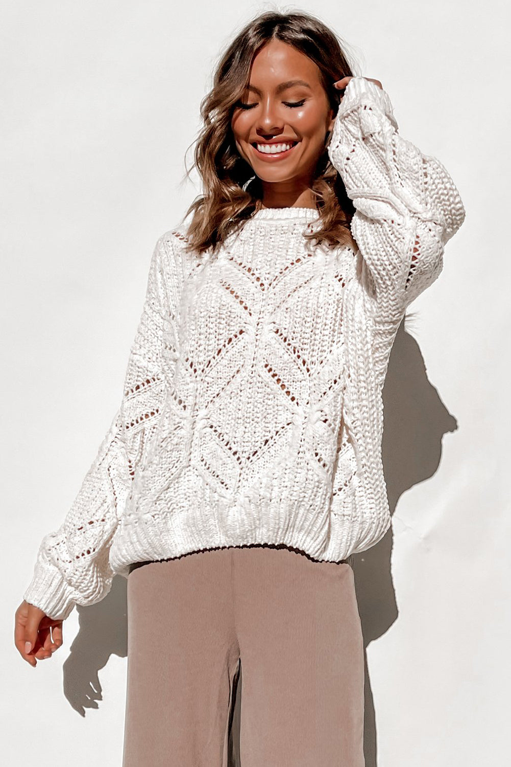 A stylish white crewneck sweater with balloon sleeves, featuring a textured knit design, perfect for casual wear.