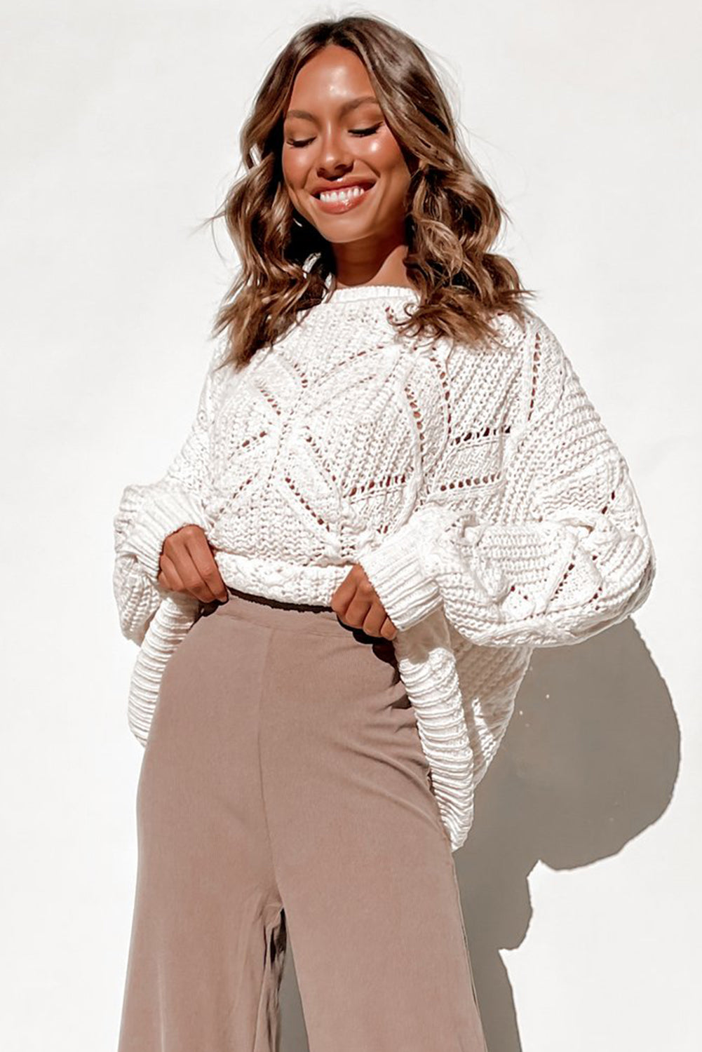 A stylish white crewneck sweater with balloon sleeves, featuring a textured knit design, perfect for casual wear.