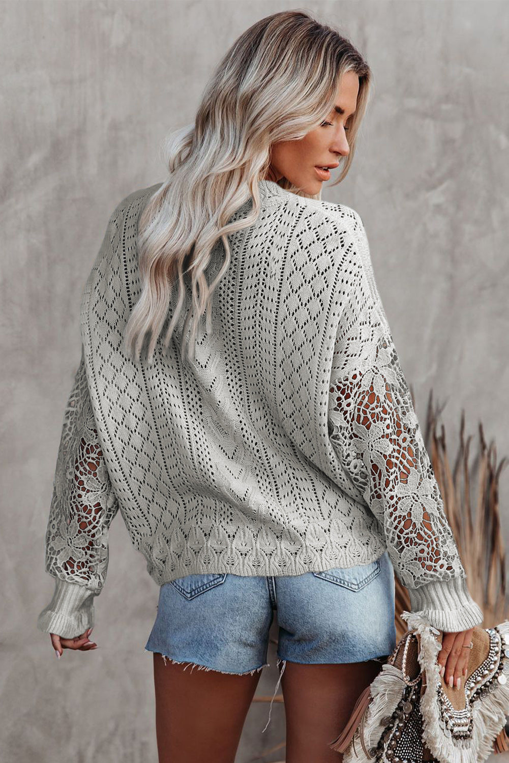 A stylish white crochet lace pointelle knit sweater featuring a scalloped neckline and sheer lace sleeves, perfect for casual and chic outfits.