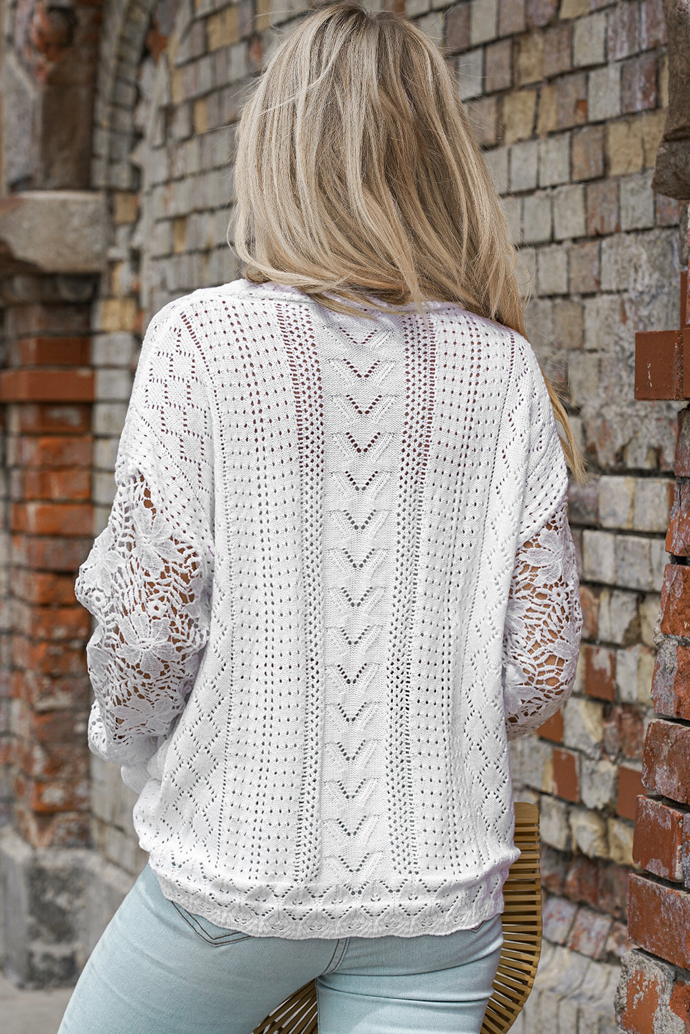 A stylish white crochet lace pointelle knit sweater featuring a scalloped neckline and sheer lace sleeves, perfect for casual and chic outfits.