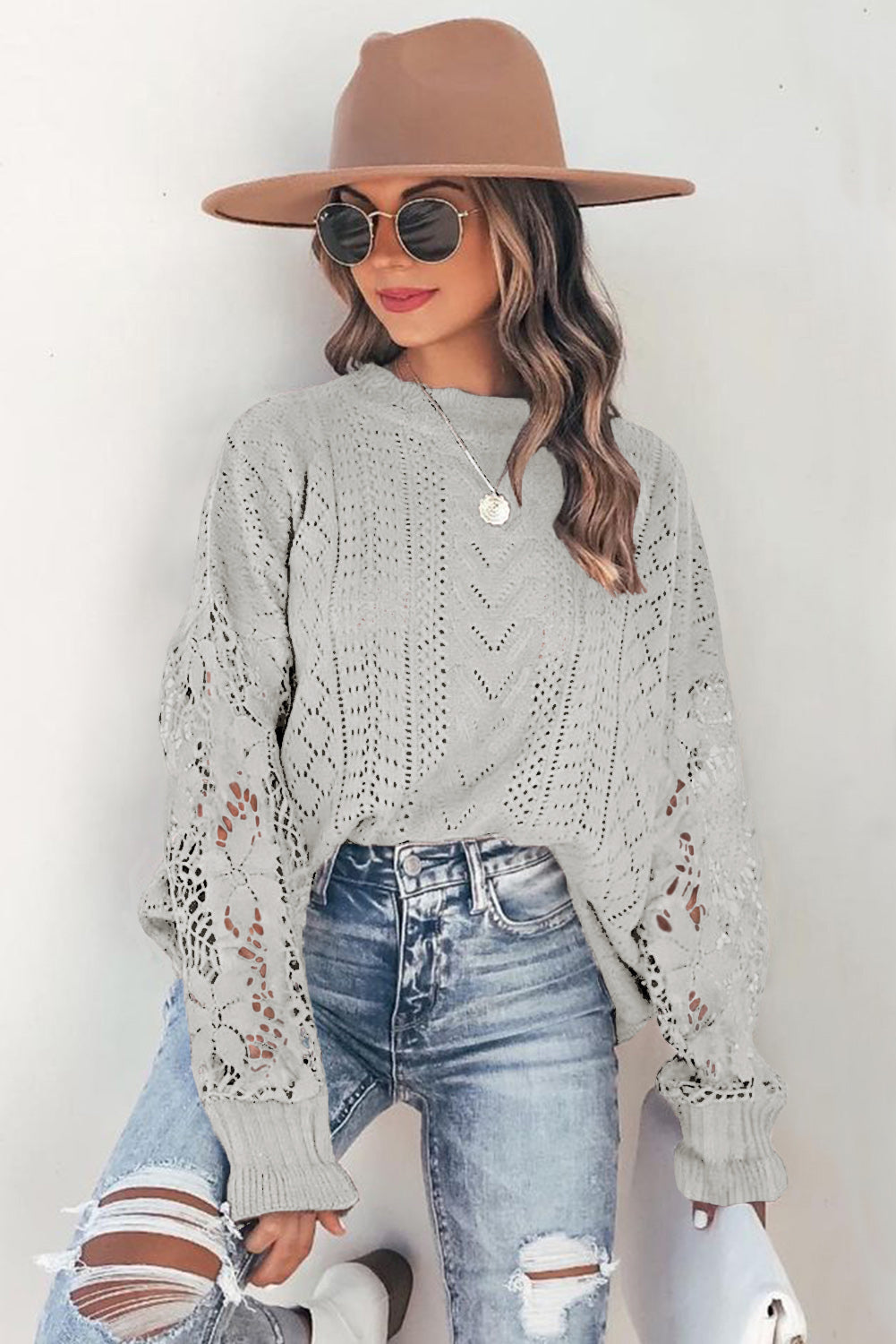 A stylish white crochet lace pointelle knit sweater featuring a scalloped neckline and sheer lace sleeves, perfect for casual and chic outfits.