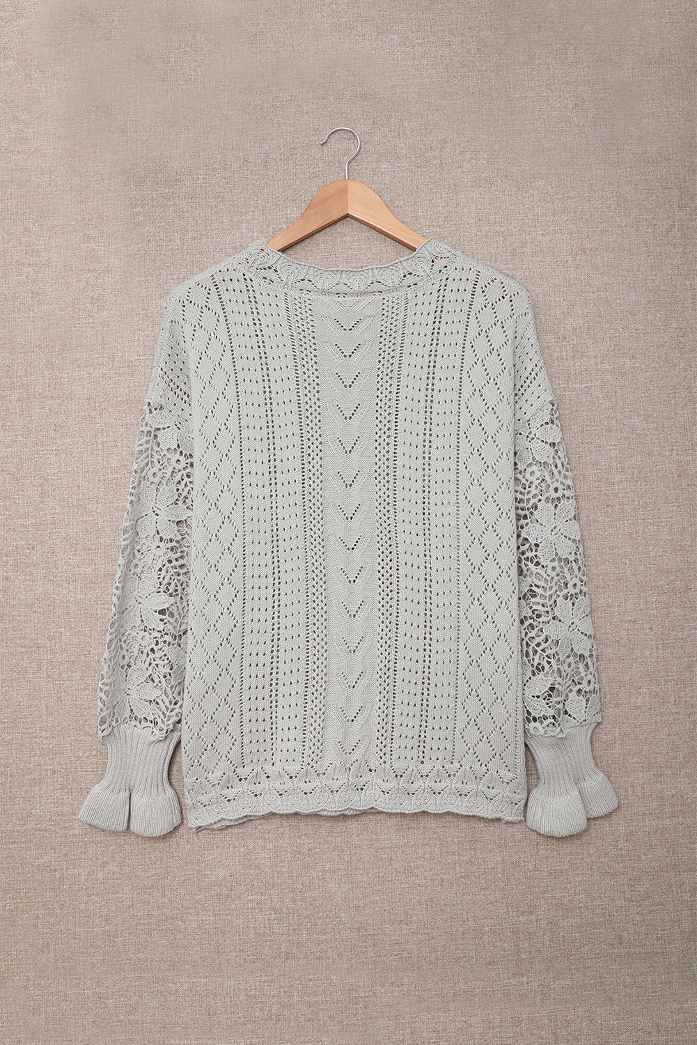 A stylish white crochet lace pointelle knit sweater featuring a scalloped neckline and sheer lace sleeves, perfect for casual and chic outfits.