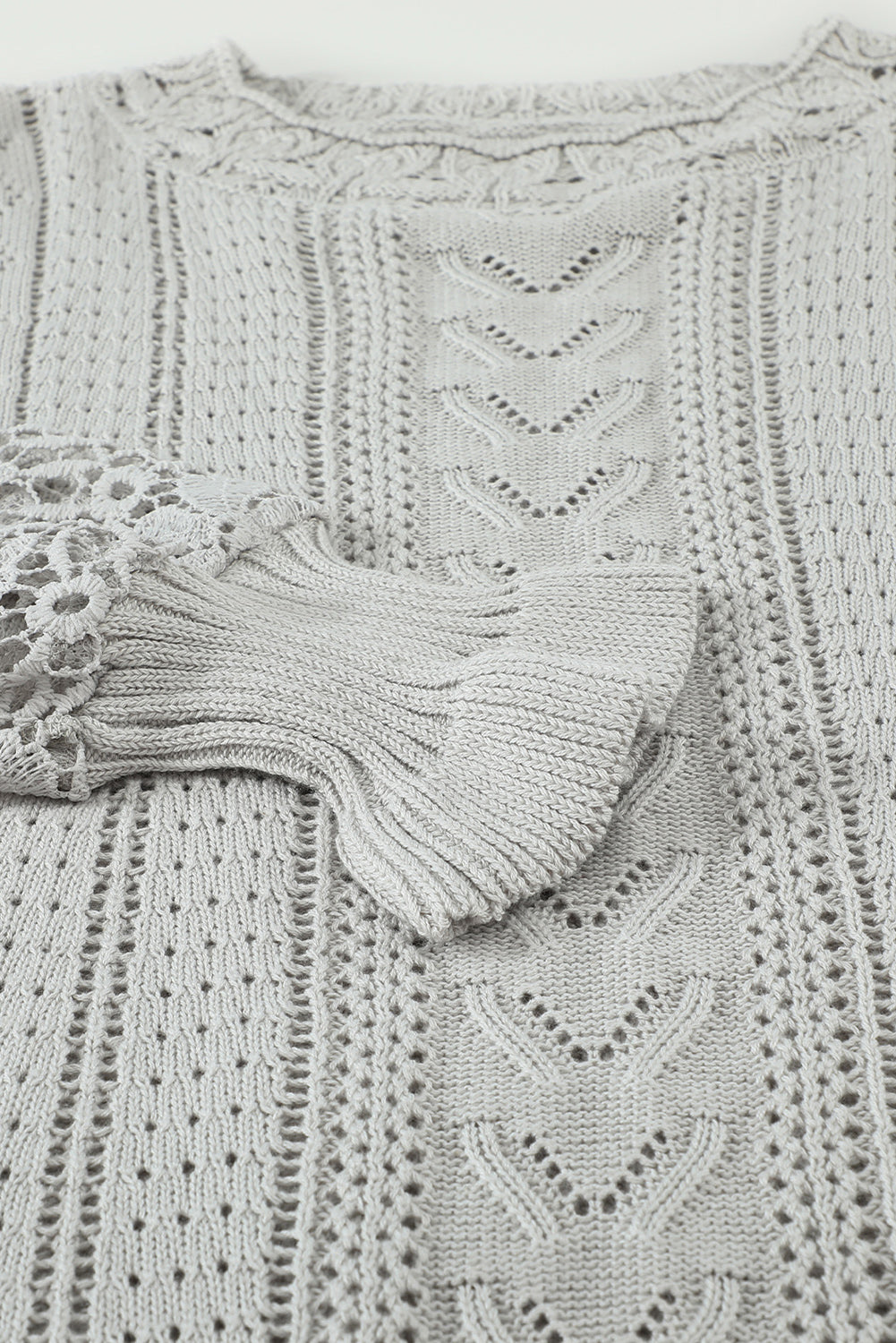 A stylish white crochet lace pointelle knit sweater featuring a scalloped neckline and sheer lace sleeves, perfect for casual and chic outfits.