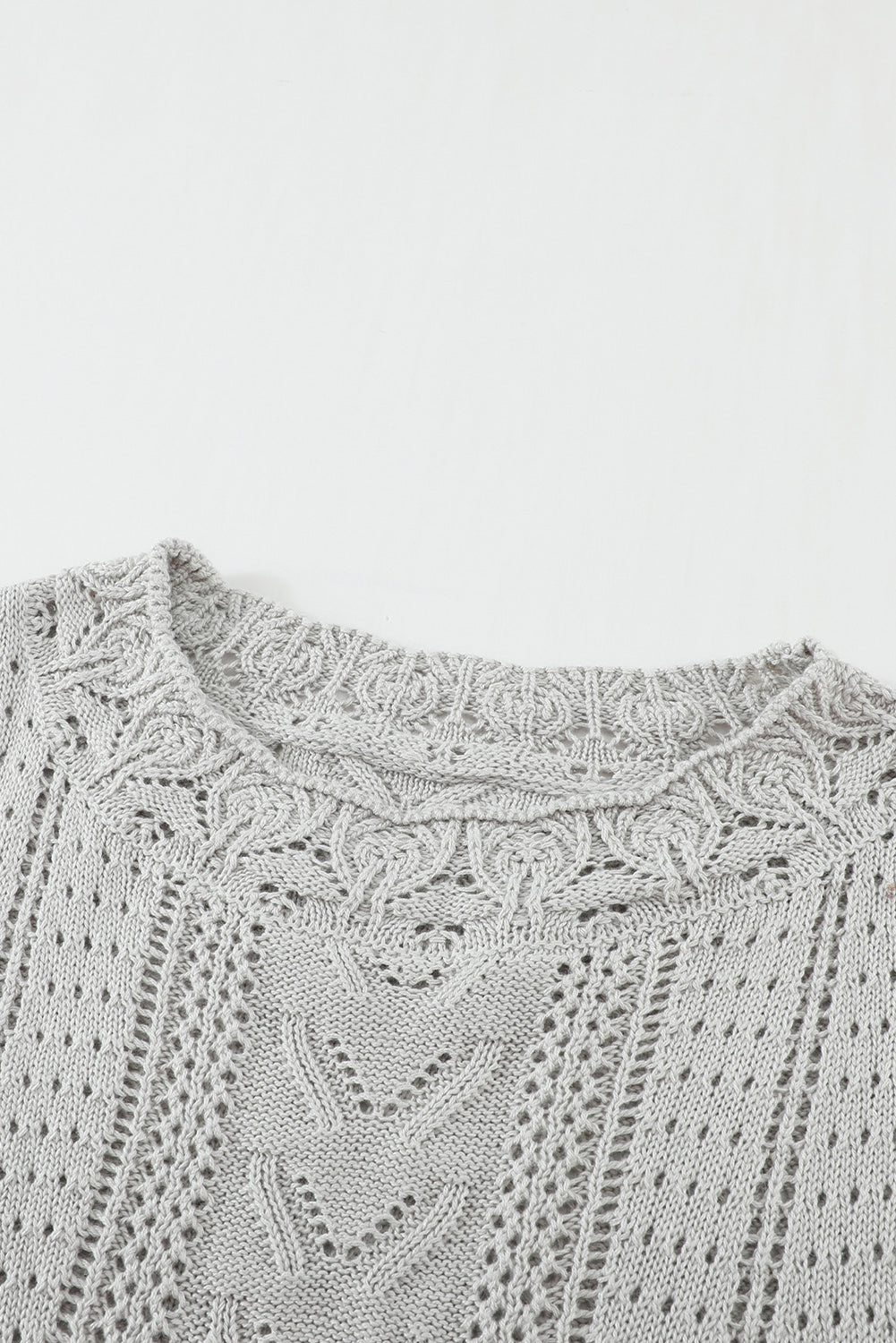 A stylish white crochet lace pointelle knit sweater featuring a scalloped neckline and sheer lace sleeves, perfect for casual and chic outfits.