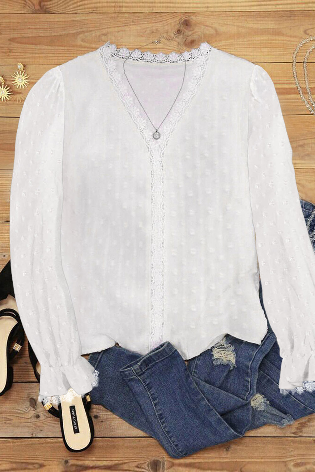 A stylish white blouse featuring a v-neck design, swiss dot pattern, and lace trim on the neckline and sleeves, perfect for casual or formal wear.