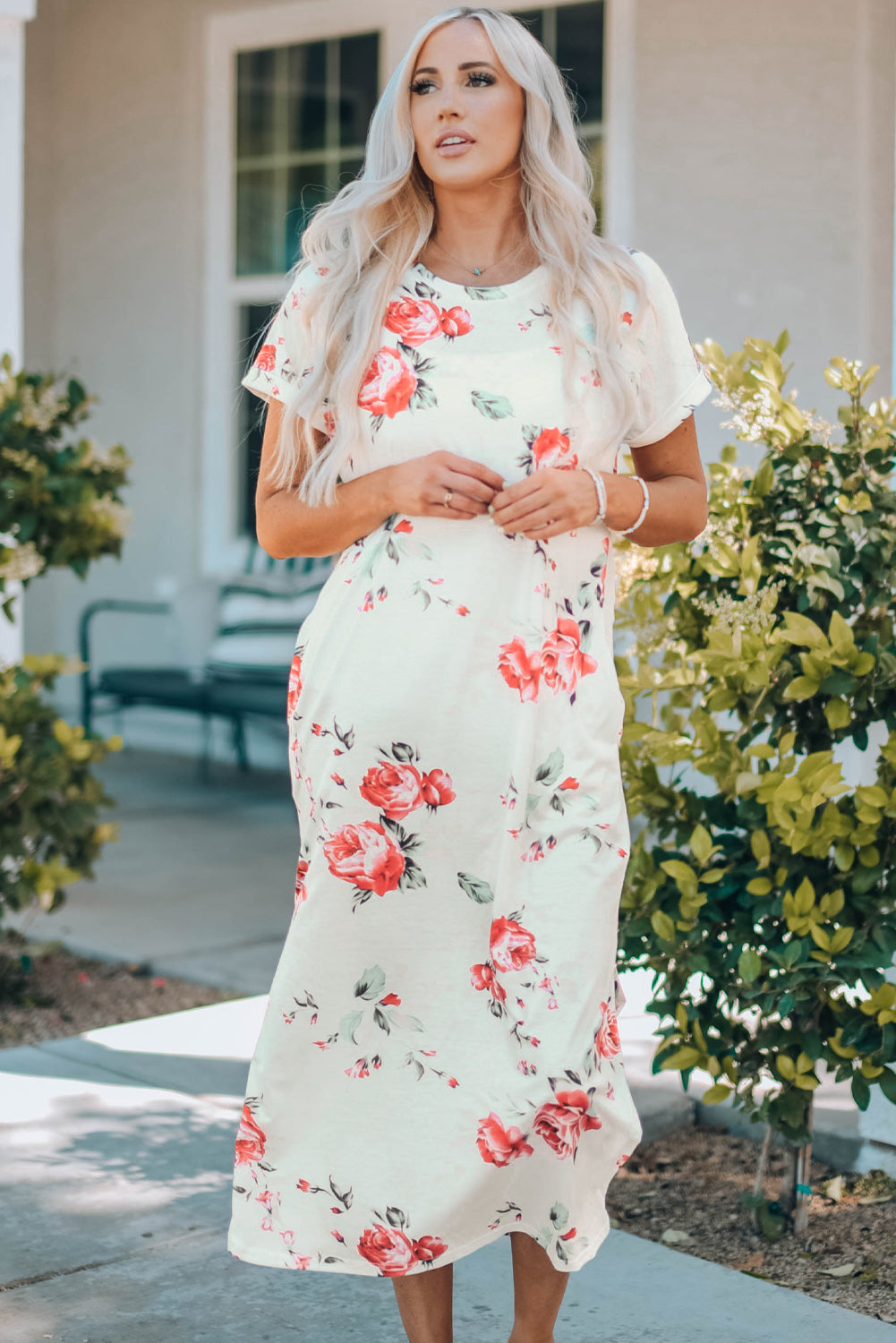 A stylish white t shirt dress featuring a vibrant floral print, side slits, and short sleeves, perfect for summer outings.