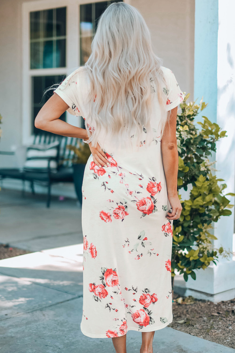 A stylish white t shirt dress featuring a vibrant floral print, side slits, and short sleeves, perfect for summer outings.