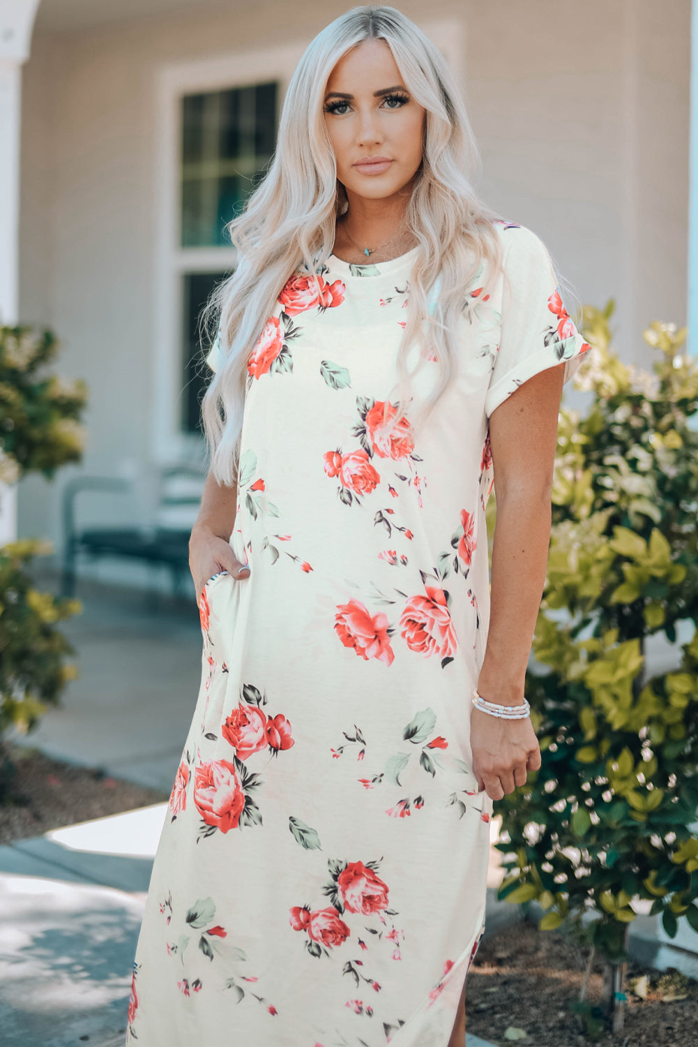 A stylish white t shirt dress featuring a vibrant floral print, side slits, and short sleeves, perfect for summer outings.