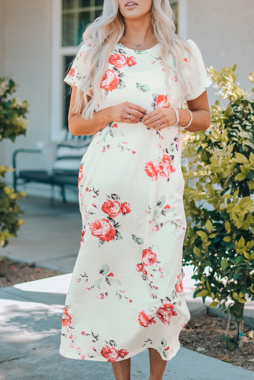 A stylish white t shirt dress featuring a vibrant floral print, side slits, and short sleeves, perfect for summer outings.