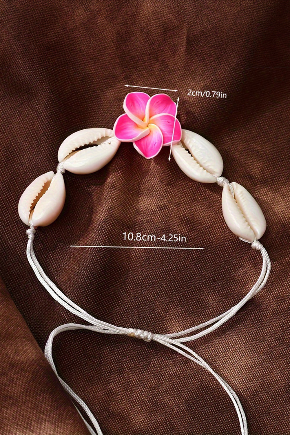 A stylish adjustable bracelet featuring a white flower design and seashell accents, perfect for any occasion.