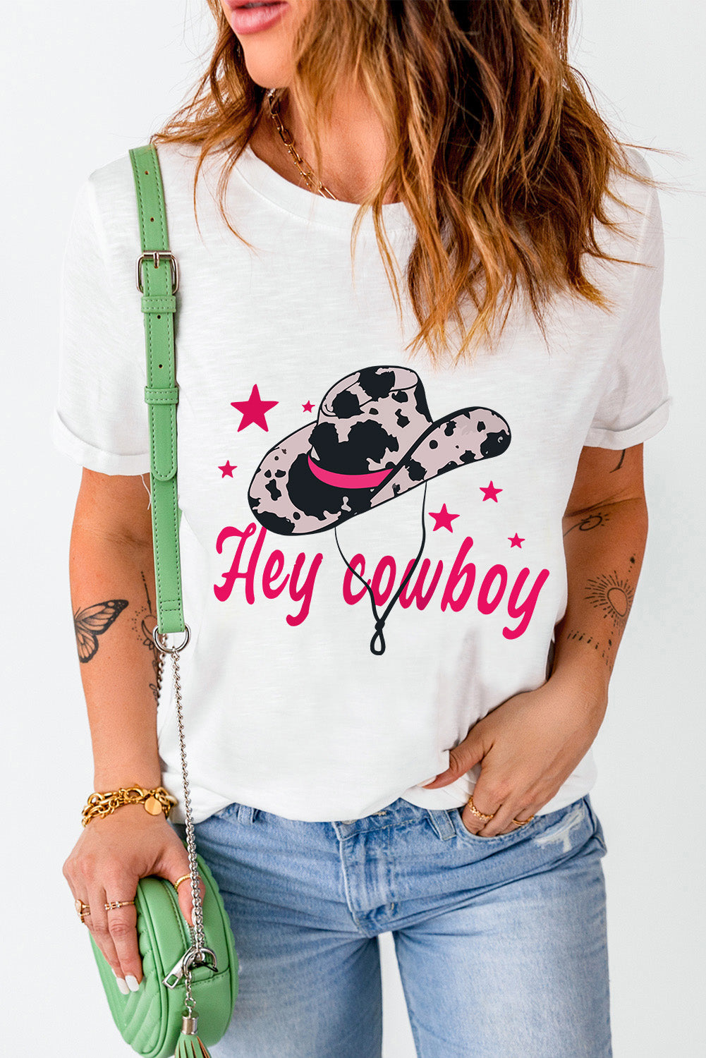 White t-shirt featuring a humorous 'Hey Cowboy' print with a bold cowboy hat design, perfect for casual wear.