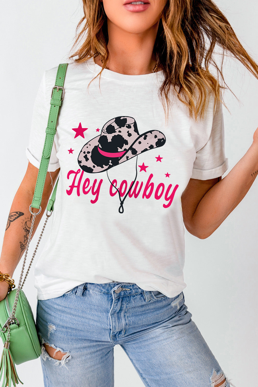 White t-shirt featuring a humorous 'Hey Cowboy' print with a bold cowboy hat design, perfect for casual wear.