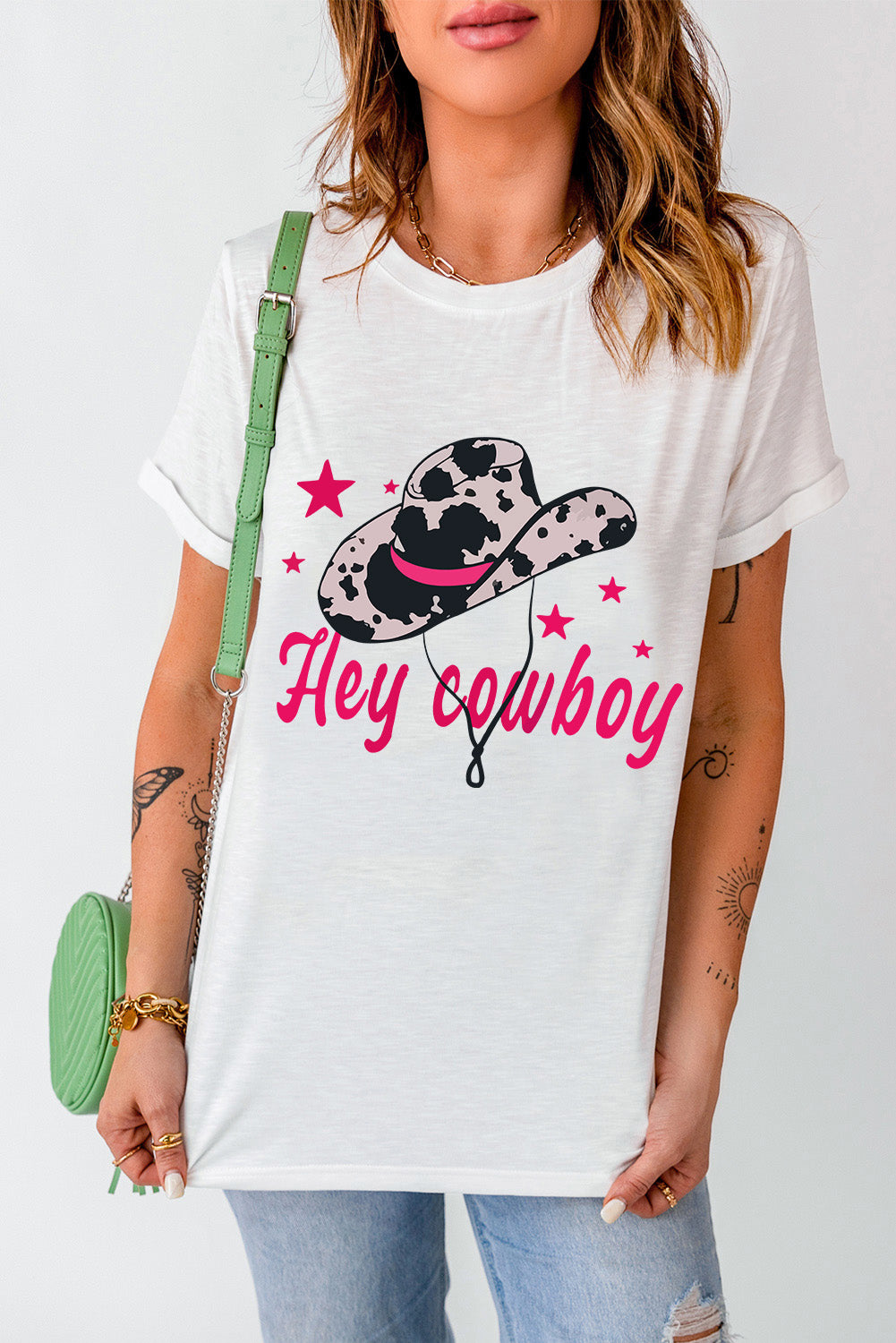 White t-shirt featuring a humorous 'Hey Cowboy' print with a bold cowboy hat design, perfect for casual wear.